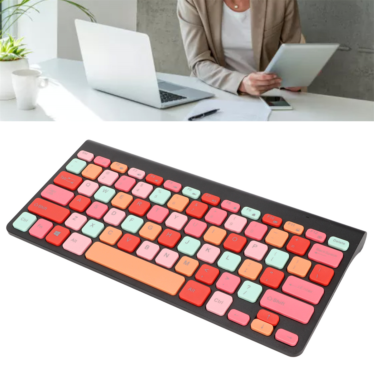 Eine bunte Tastatur mit rosa, orangefarbenen und grünen Tasten. Eine Person benutzt Tablet und Laptop.