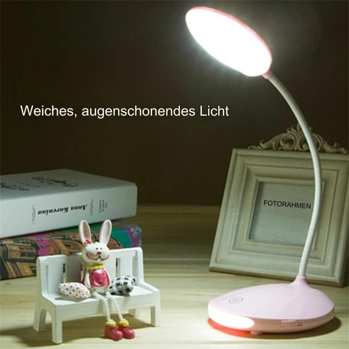 Eine rosa Schreibtischlampe beleuchtet eine Bank mit einer Hasenfigur, Büchern und einem Fotorahmen.
