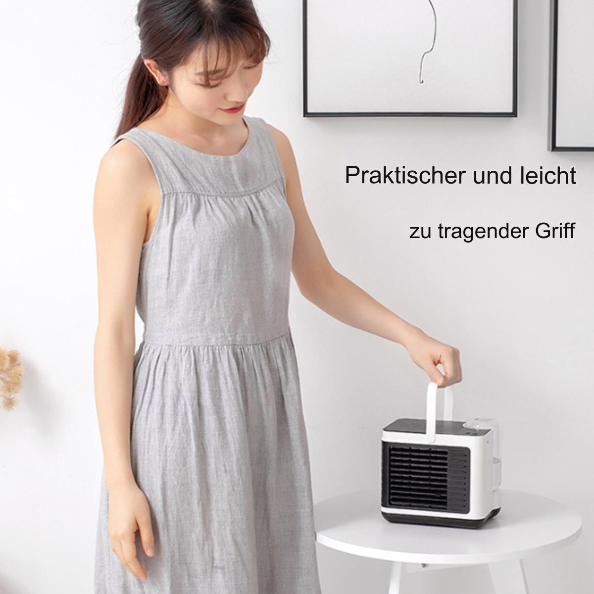 Eine Frau hält einen kleinen weißen und schwarzen Kühler. Er steht auf einem weißen Tisch mit weißem Hintergrund.