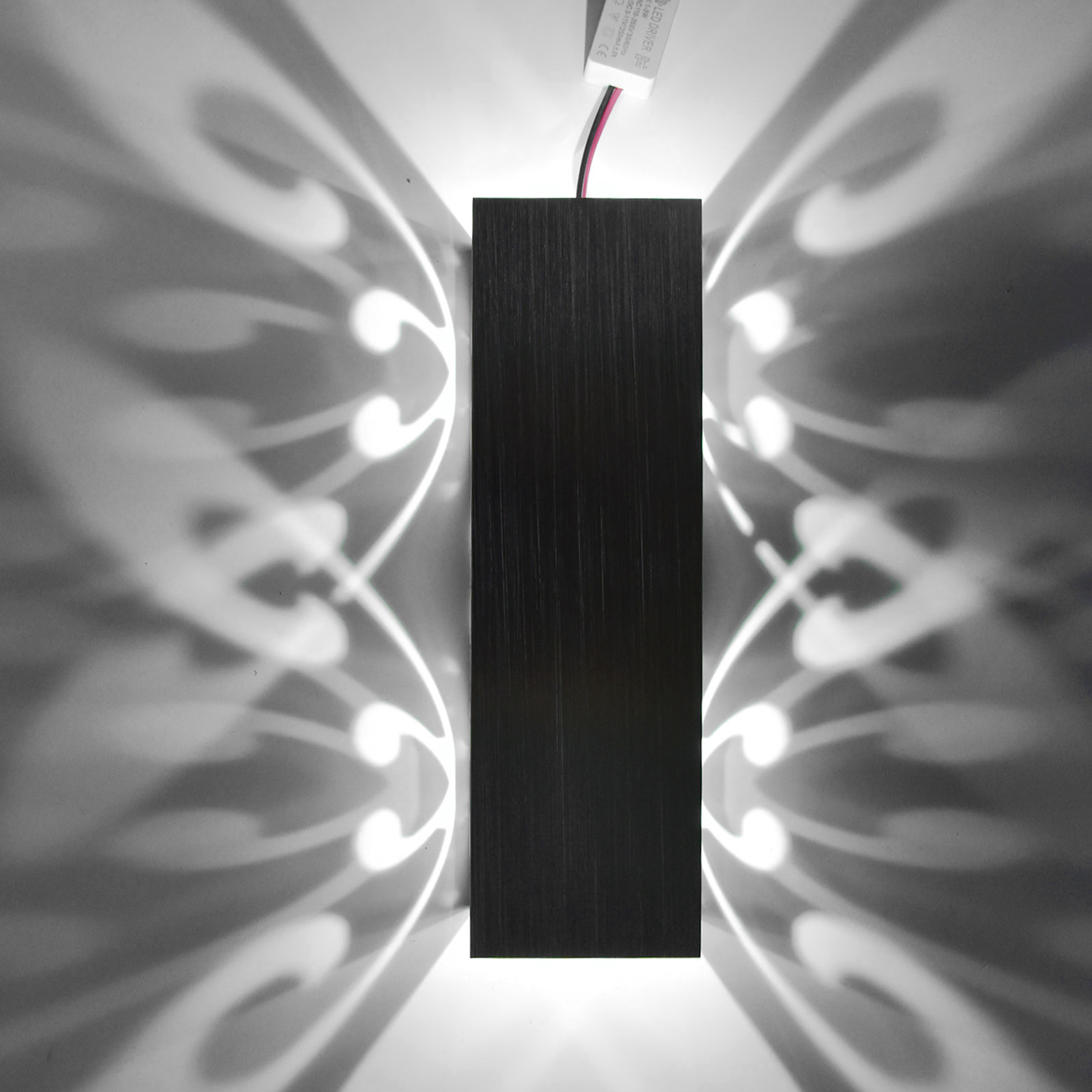 Schwarze Wandlampe mit Lichtdesign an der Wand.