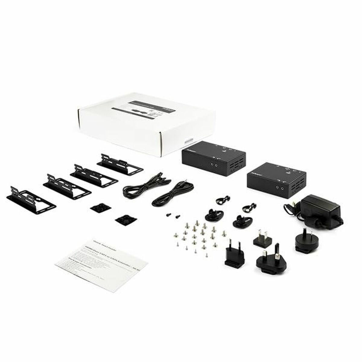 Un conjunto de accesorios informáticos negros, incluyendo cajas pequeñas, cables y adaptadores sobre blanco.