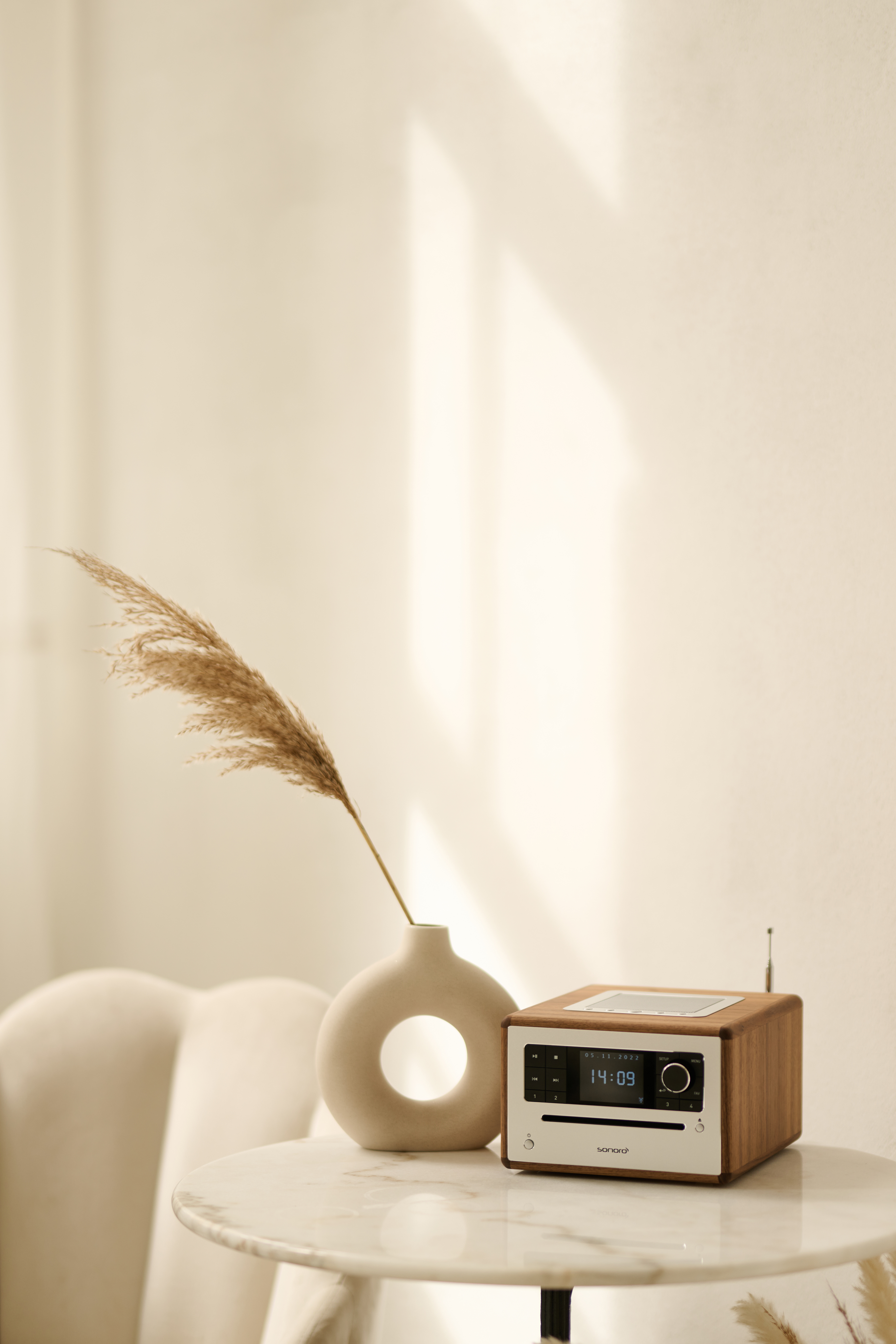 Interieur: een radio, een vaas met pampasgras op een marmeren tafel.