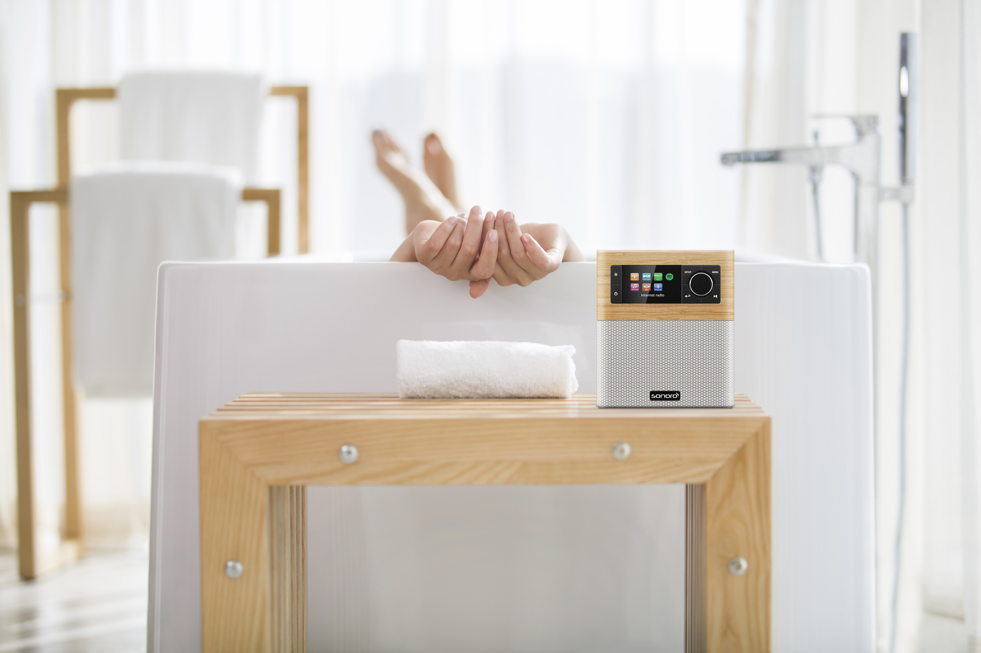 Osoba w wannie używająca małego inteligentnego radia.