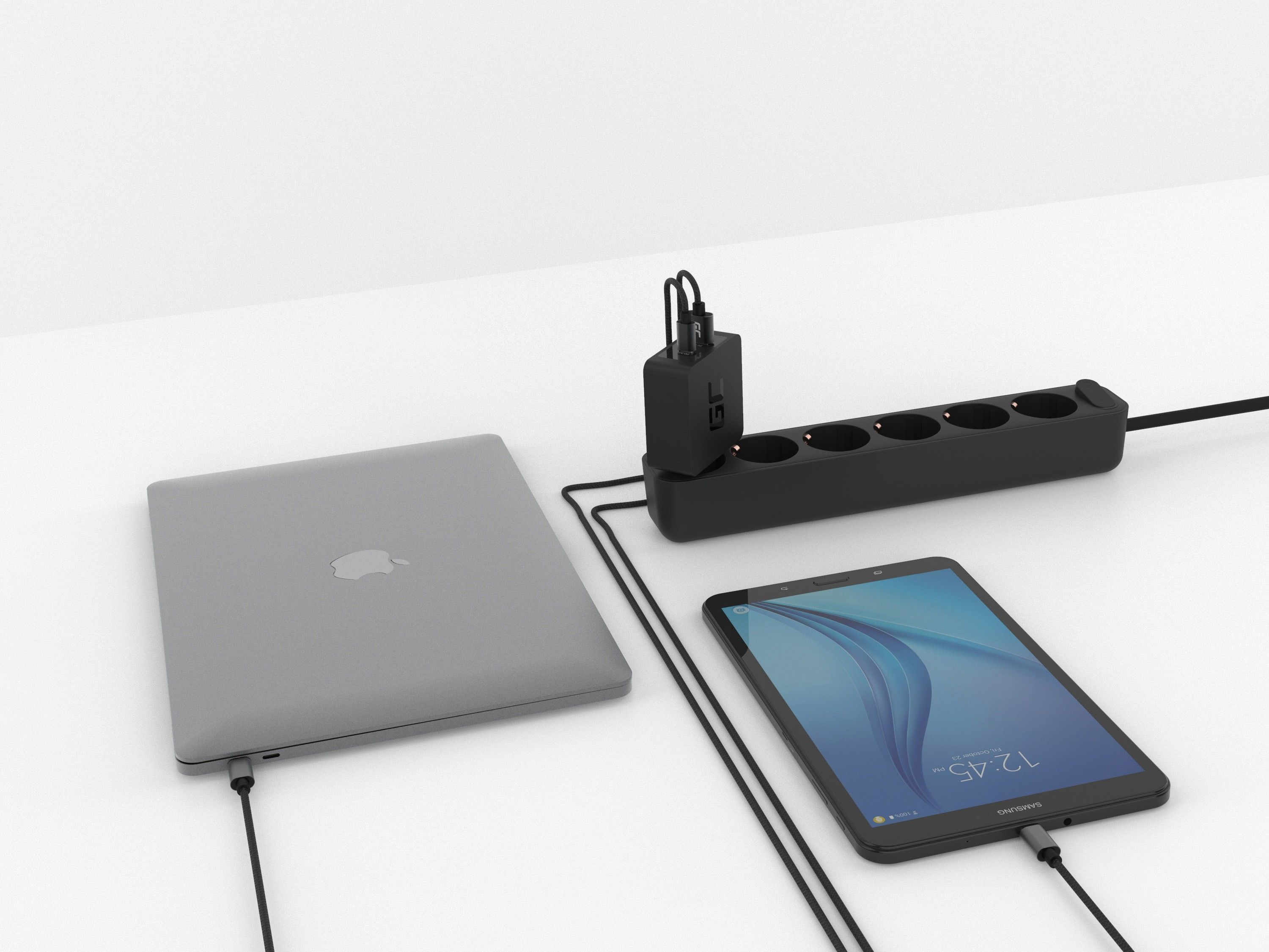 Laptop, Tablet und Steckdosenleiste mit Ladegerät und angeschlossenen Kabeln, auf weißer Oberfläche.