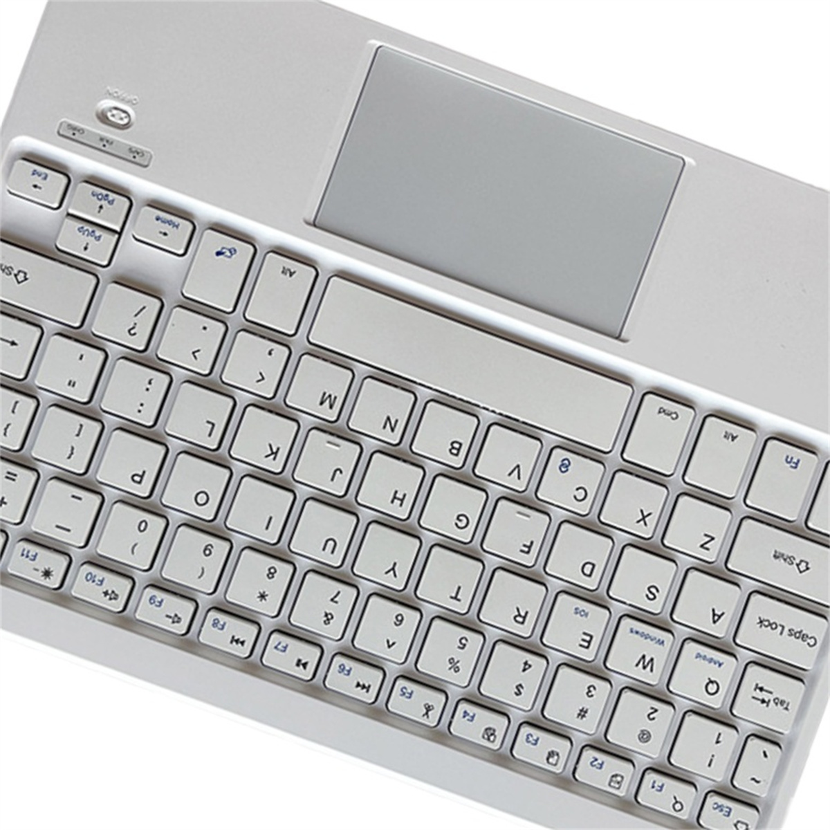 Weiße Tastatur mit Touchpad und Tasten, abgewinkelt auf weißer Oberfläche.