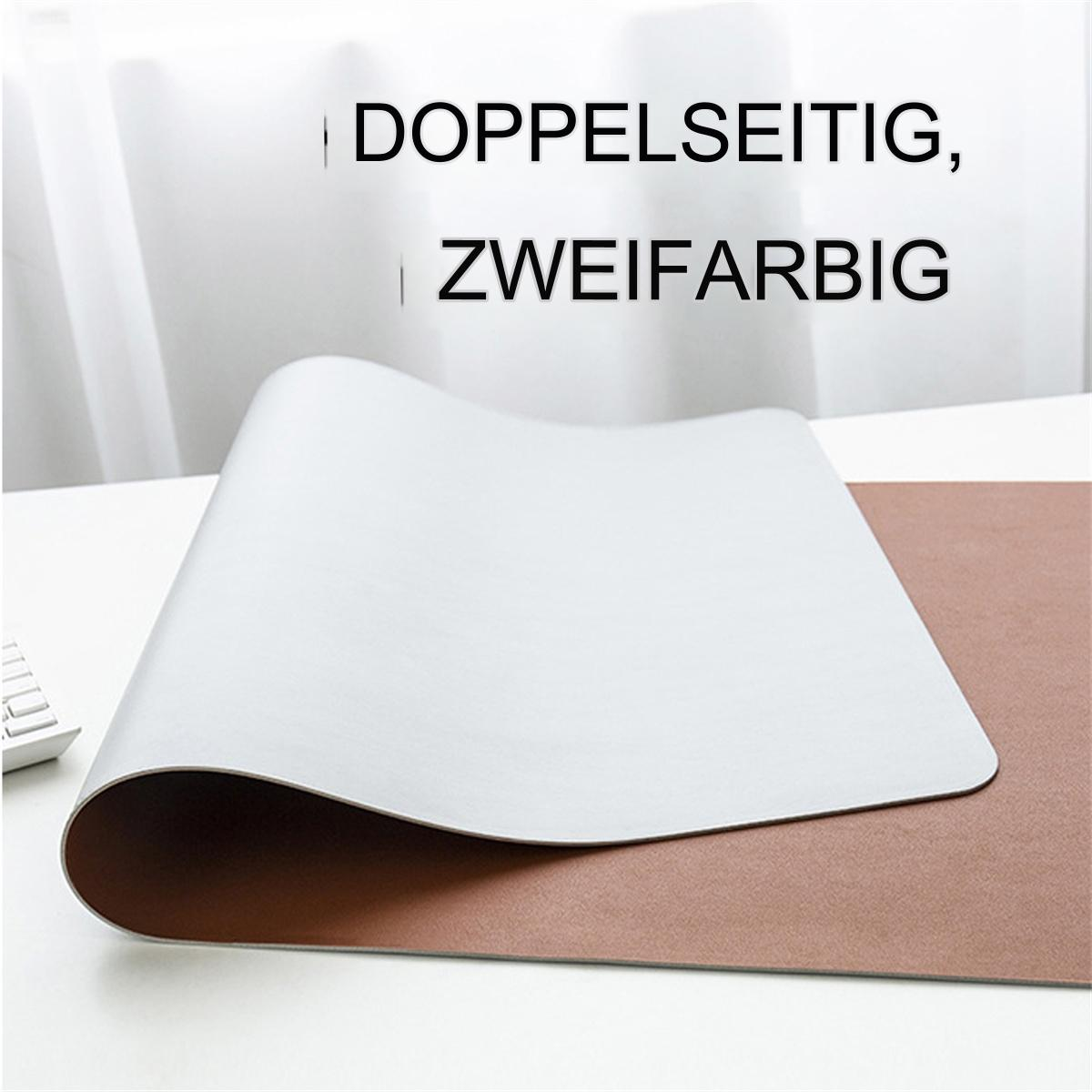 Doppelseitige weiß-braune Schreibtischunterlage auf einem weißen Tisch. Weiße Seite oben, braune Seite sichtbar.