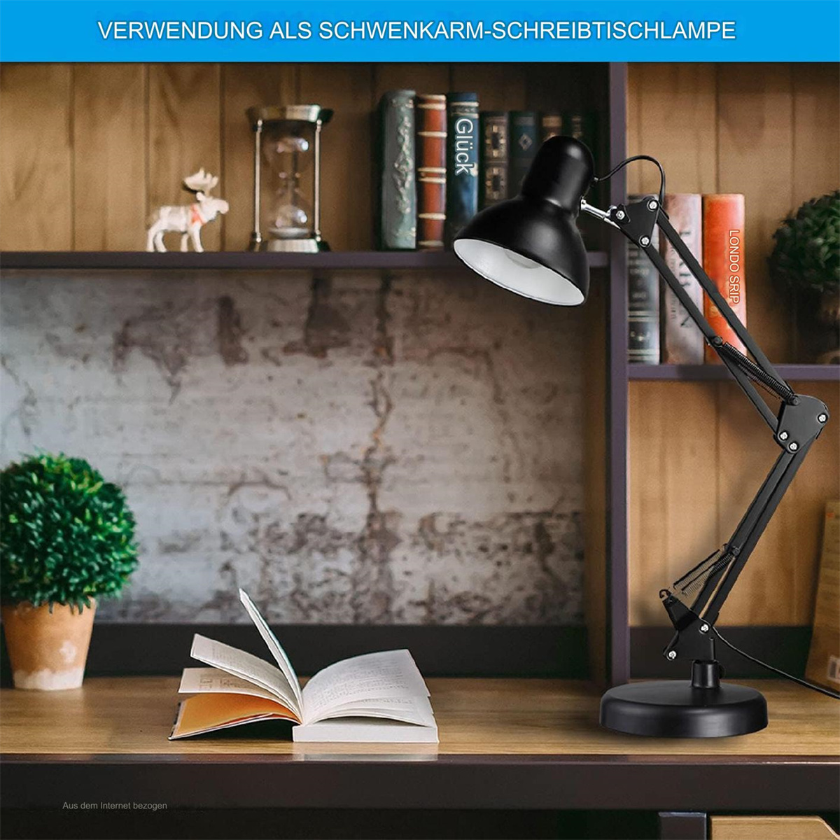 Eine schwarze Schreibtischlampe mit einem Buch und einer Pflanze auf einem Schreibtisch. Der Hintergrund zeigt ein Bücherregal und ein Deko-Objekt.