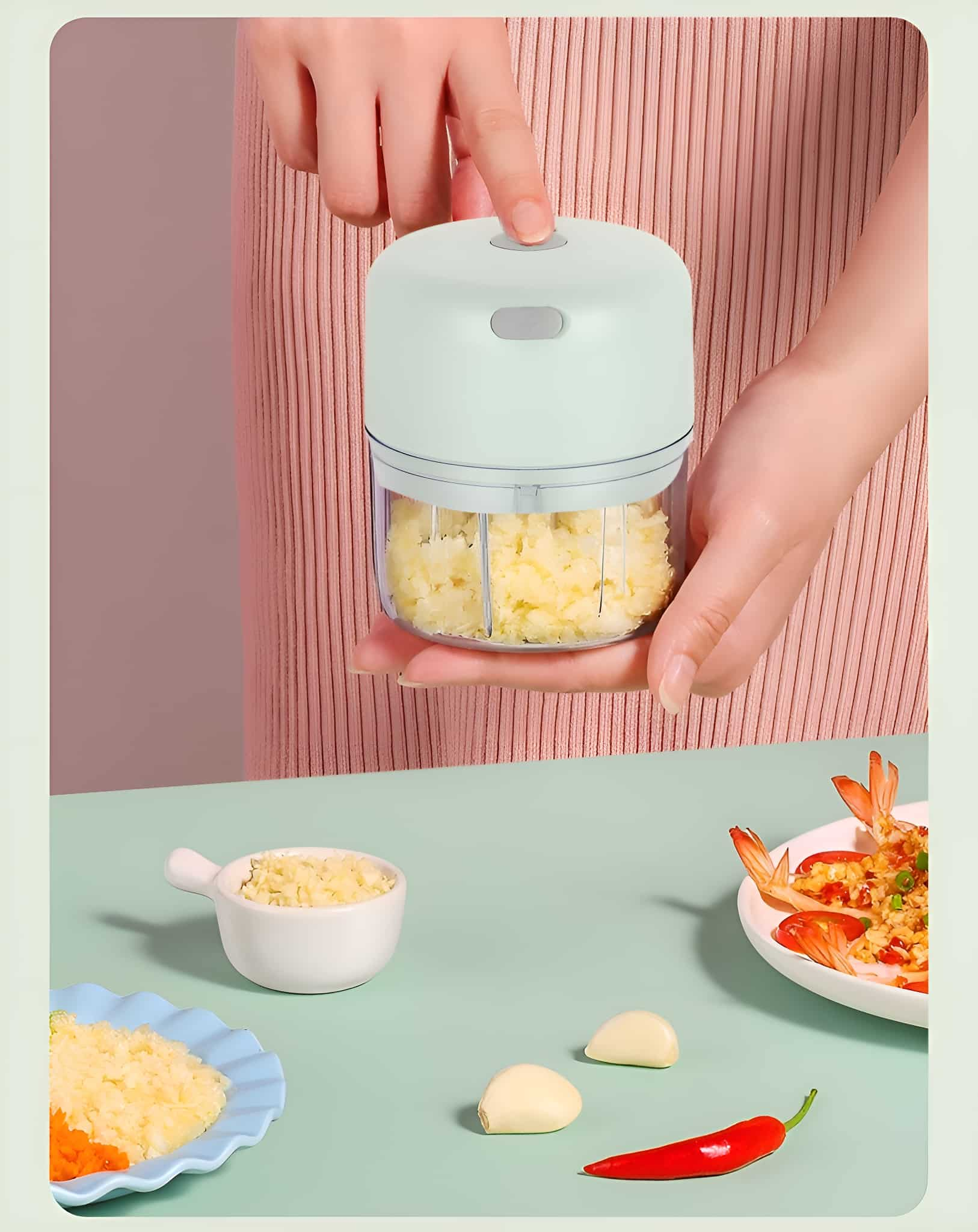 Hände halten einen Mini-Foodprozessor mit gehackten Lebensmitteln, in der Nähe von Zutaten.
