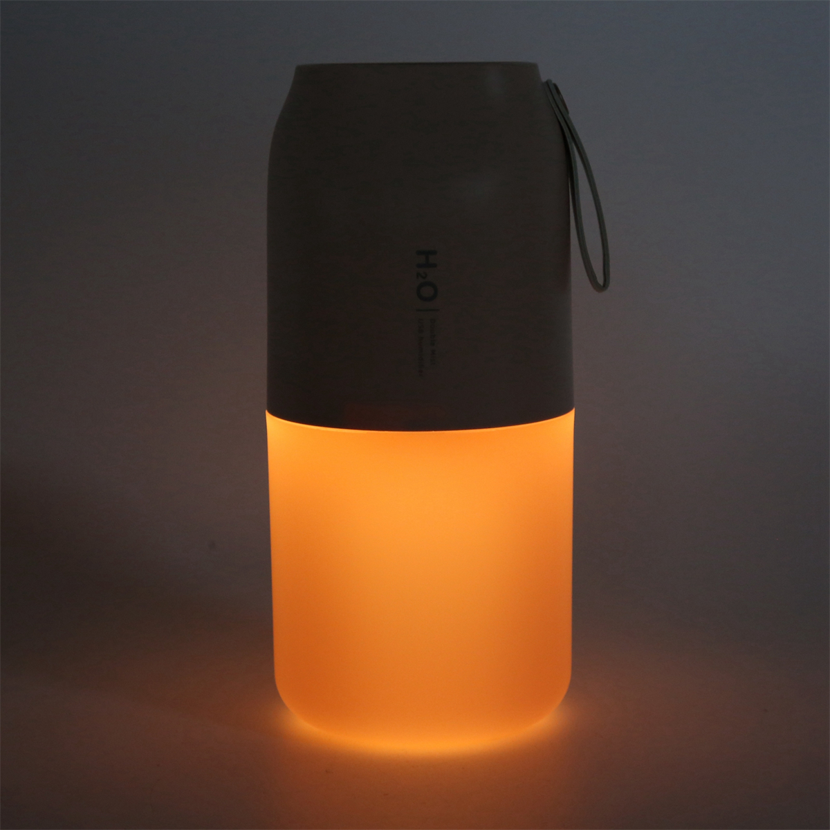 Eine leuchtend orangefarbene Lampe mit Griff. Die untere Hälfte leuchtet hell, die obere ist grau.