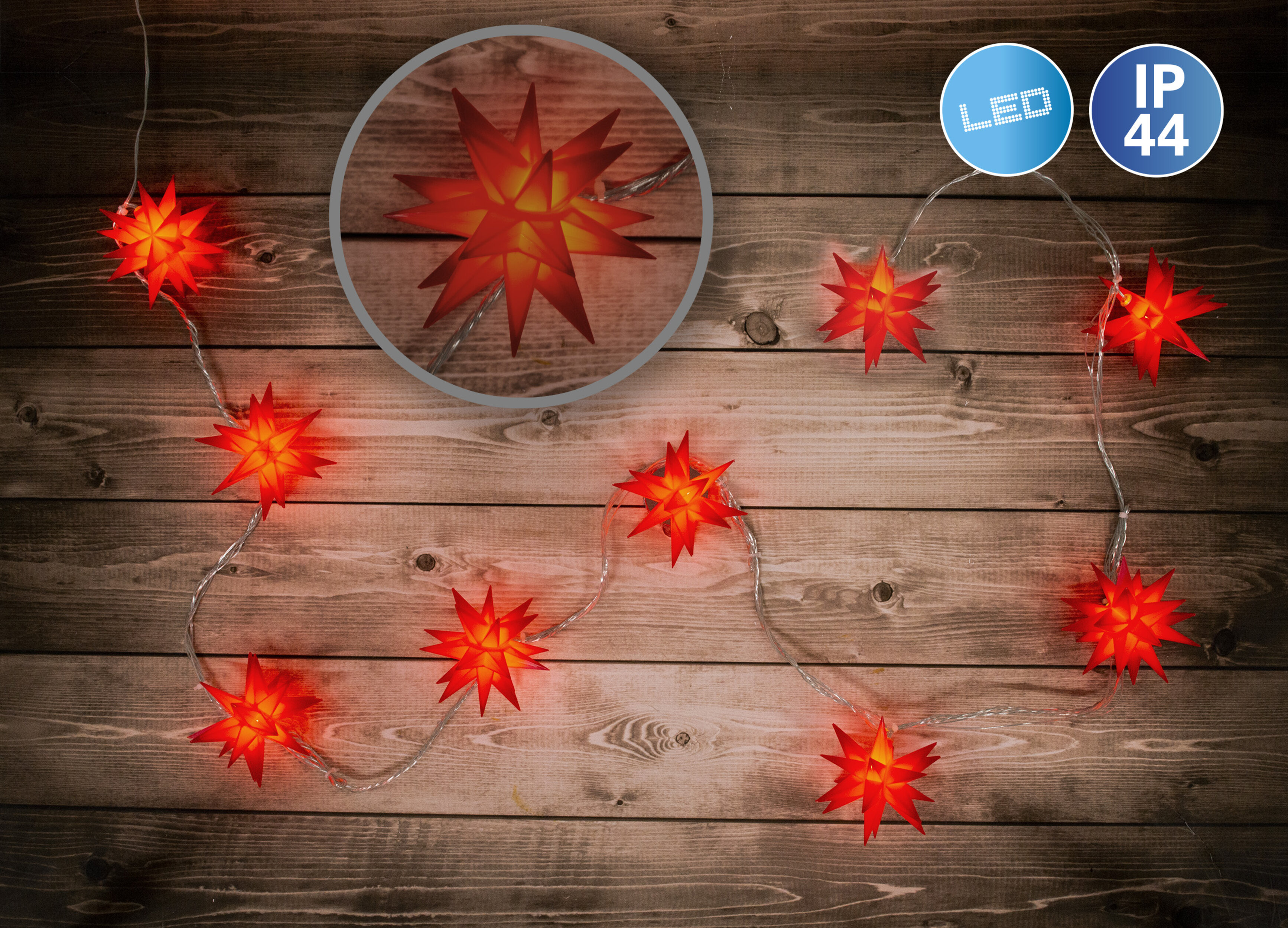 Weihnachtsbeleuchtung mit Sternformen. Sie sind rot beleuchtet. Holziger Hintergrund.