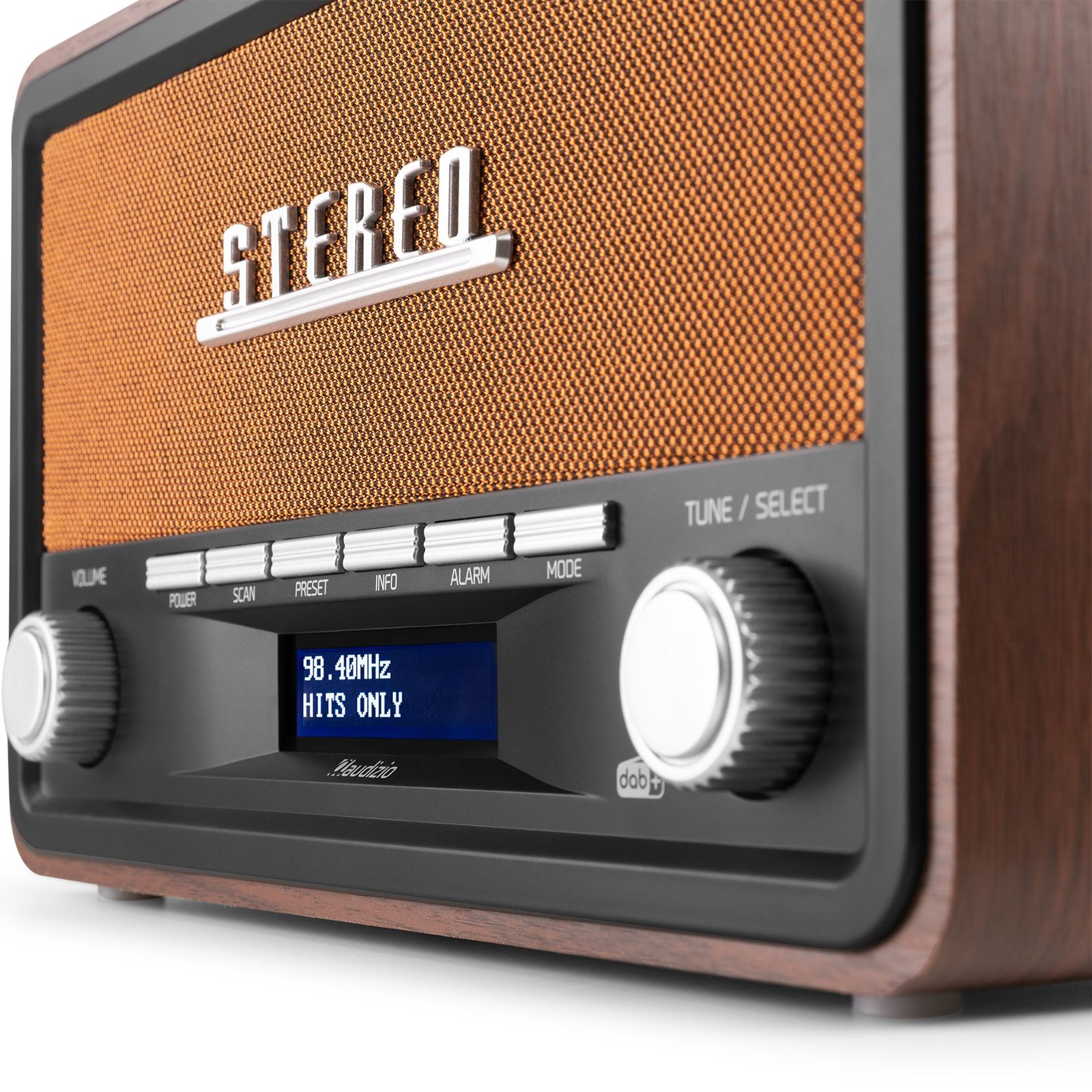 Radio de estilo retro. Frente de malla marrón con una pantalla que muestra la emisora. Perillas de volumen y sintonización a la izquierda.