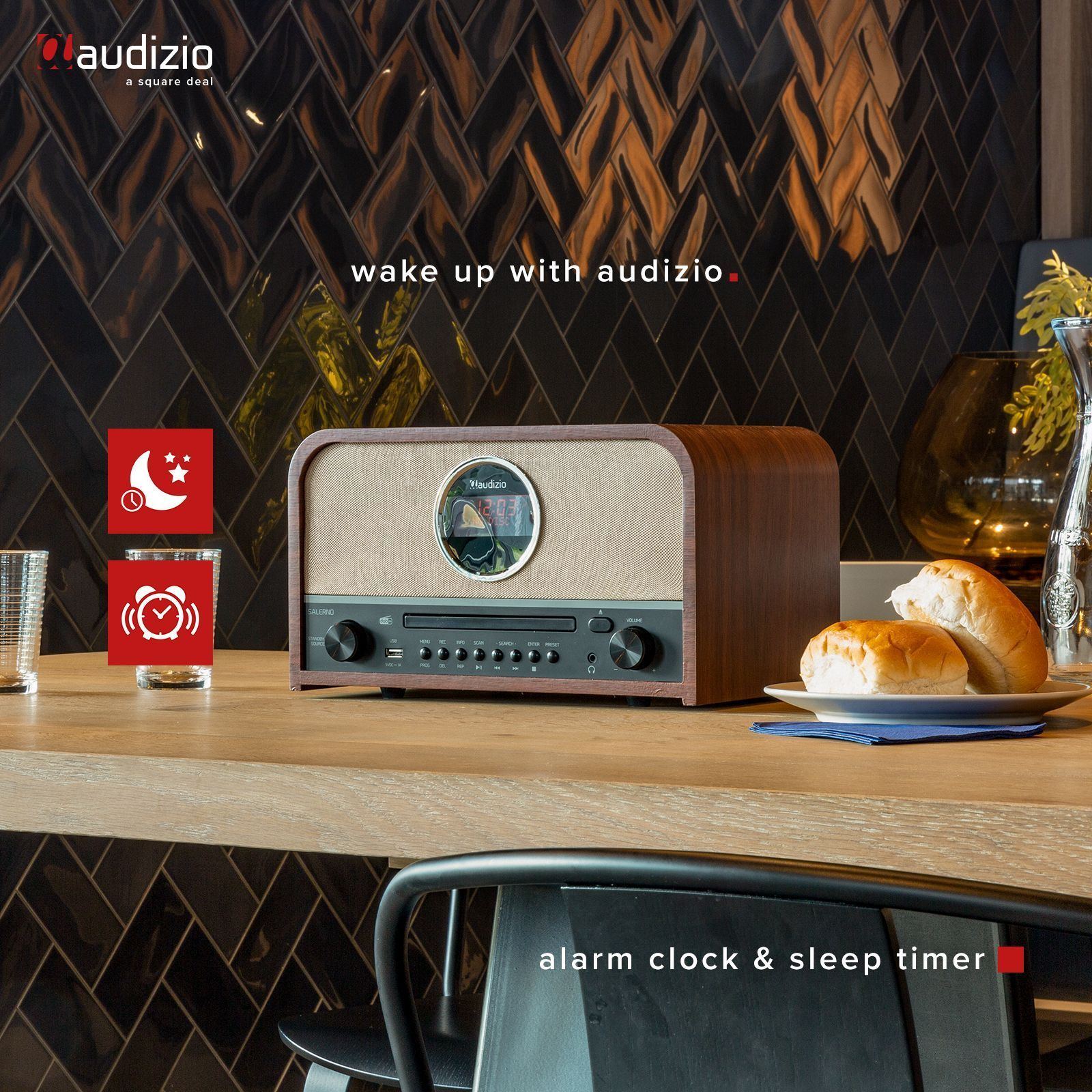 Ein Holzradio mit Display. Auf einem Tisch stehen ein Teller mit Brot, ein Glas und Kaffee.