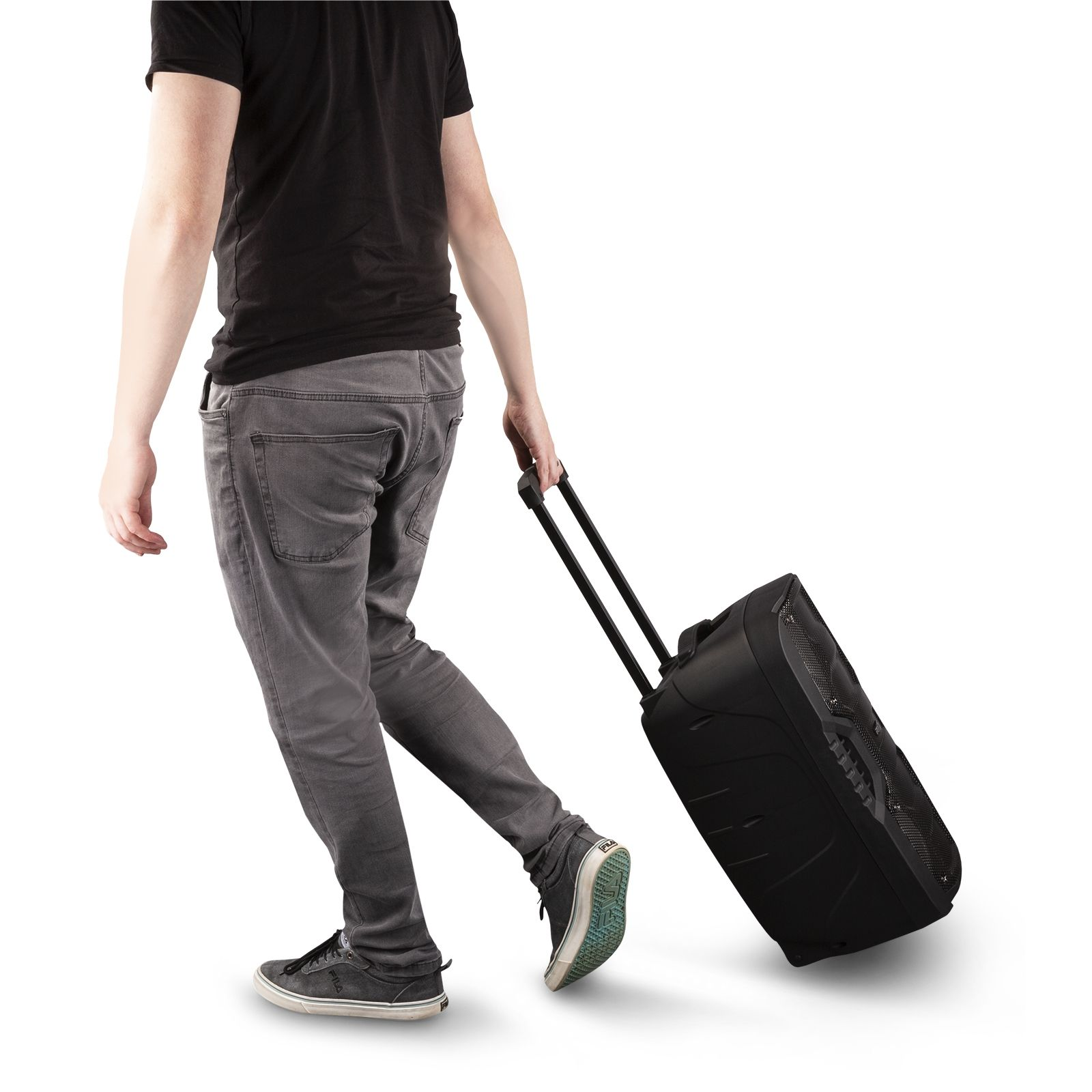 Een persoon trekt een zwarte rollende luidspreker. Ze draagt een grijze broek en een zwart shirt.
