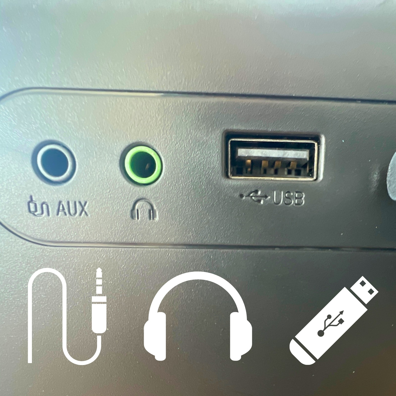 Nahaufnahme von Audioanschlüssen, einschließlich Aux, Kopfhörer und USB, mit Symbolen.