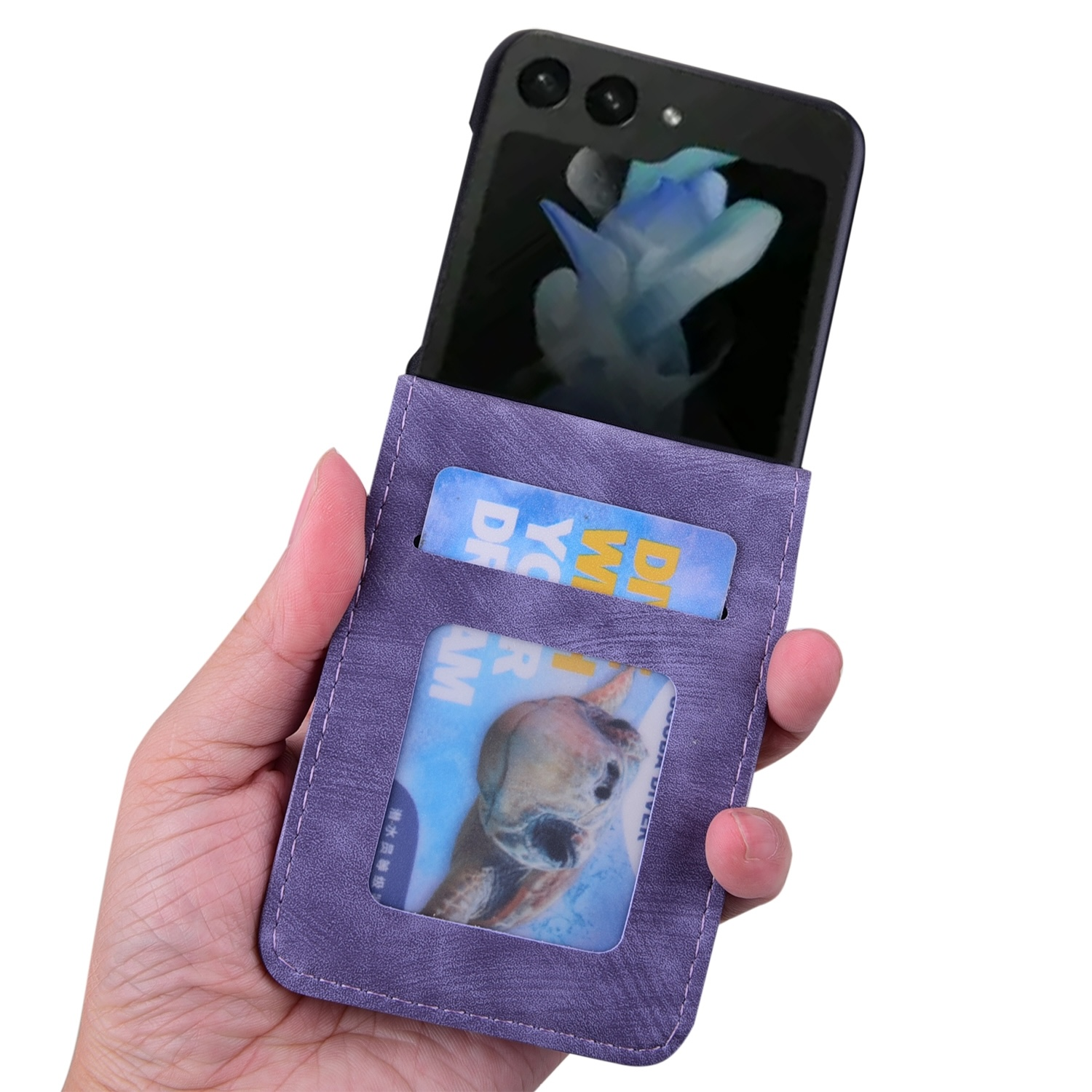Hand hält eine lila Handyhülle mit Karten. Telefon ist sichtbar. Hintergrund ist weiß.