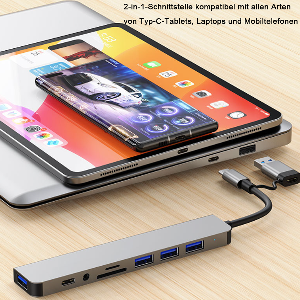 Ein Tablet, ein Telefon und ein Laptop sind gestapelt. Ein USB-Hub befindet sich im Vordergrund. Kabel verbinden die Geräte.