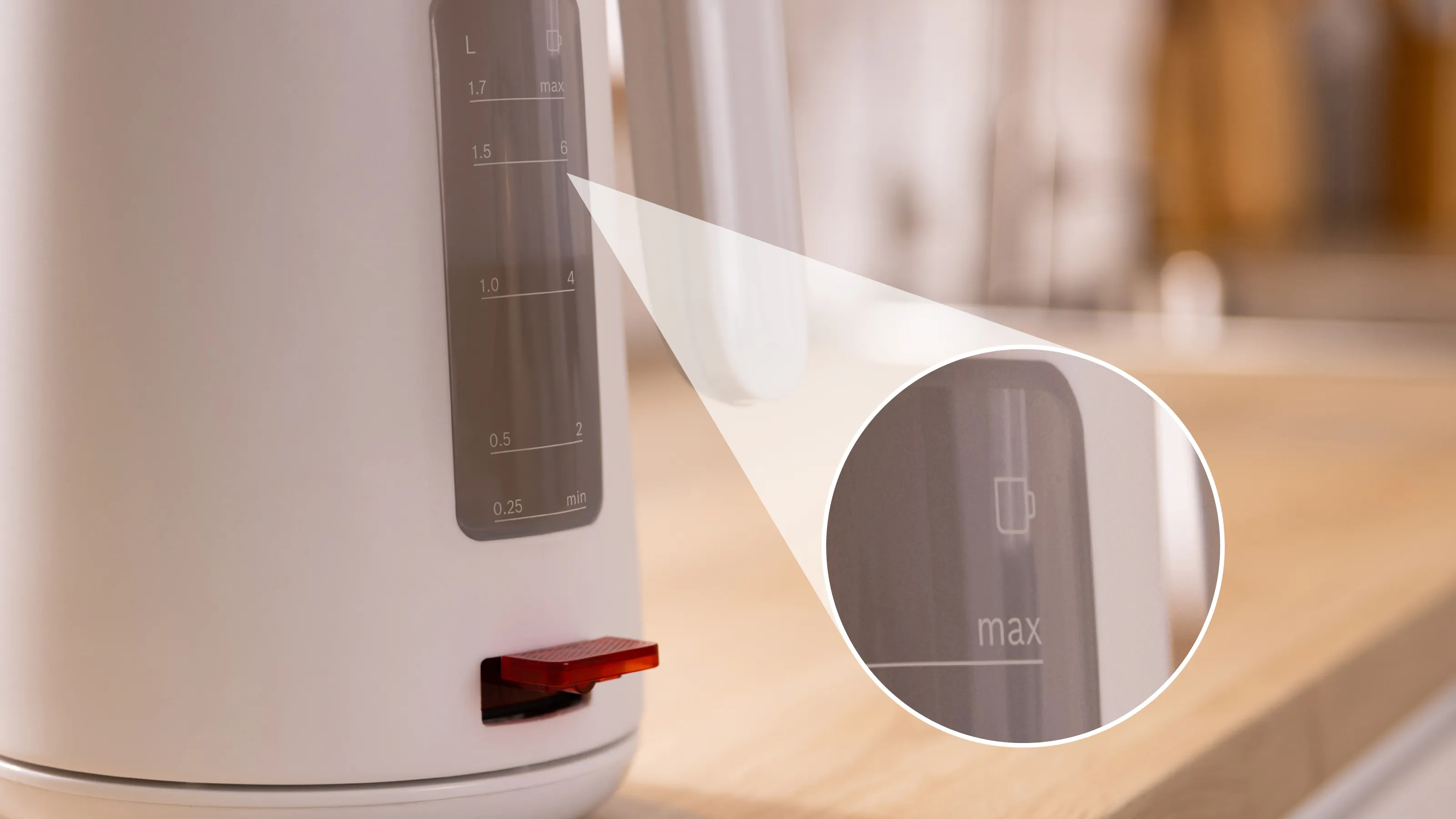 Biały czajnik elektryczny z czerwoną dźwignią i przezroczystym okienkiem ze wskaźnikami poziomu wody. Zbliżenie.