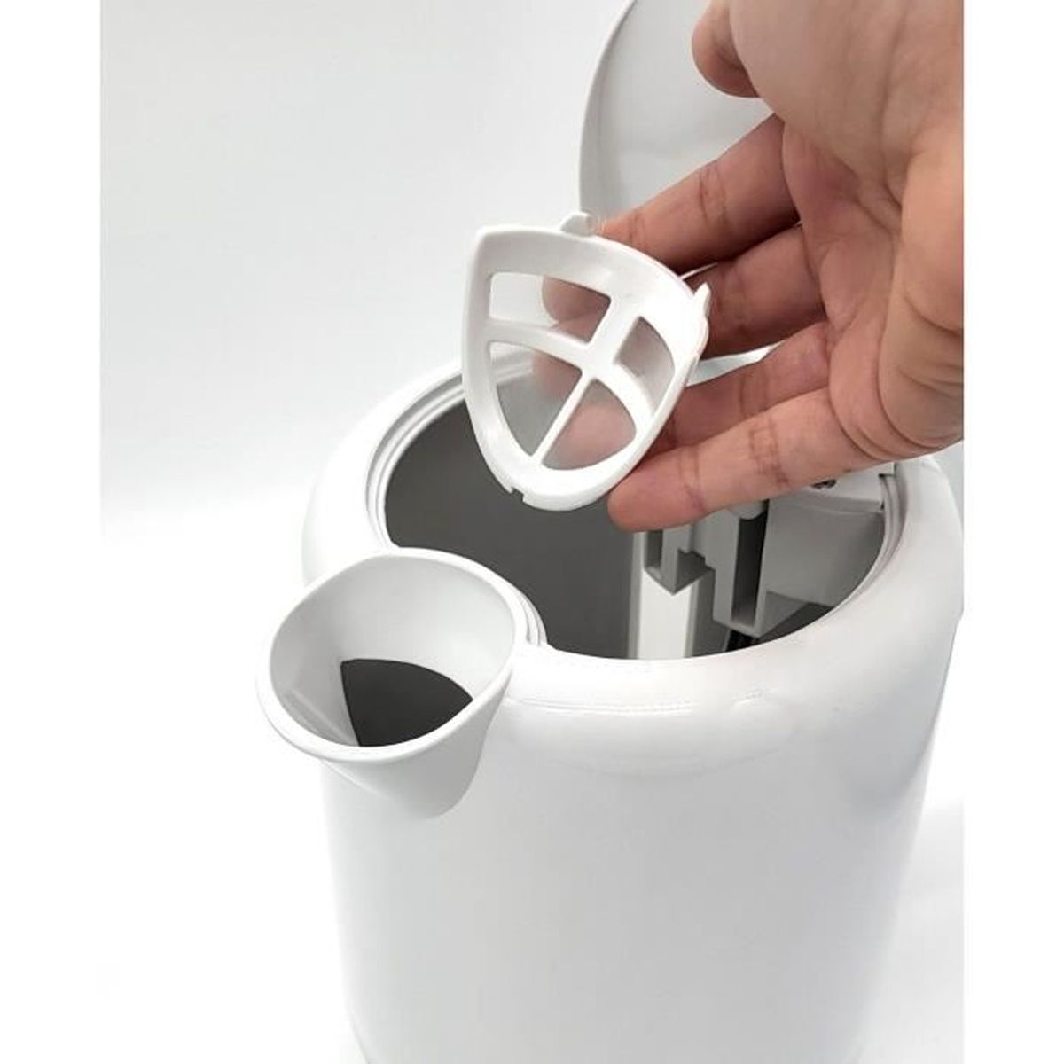 Biały plastikowy przedmiot z ręką trzymającą filtr.