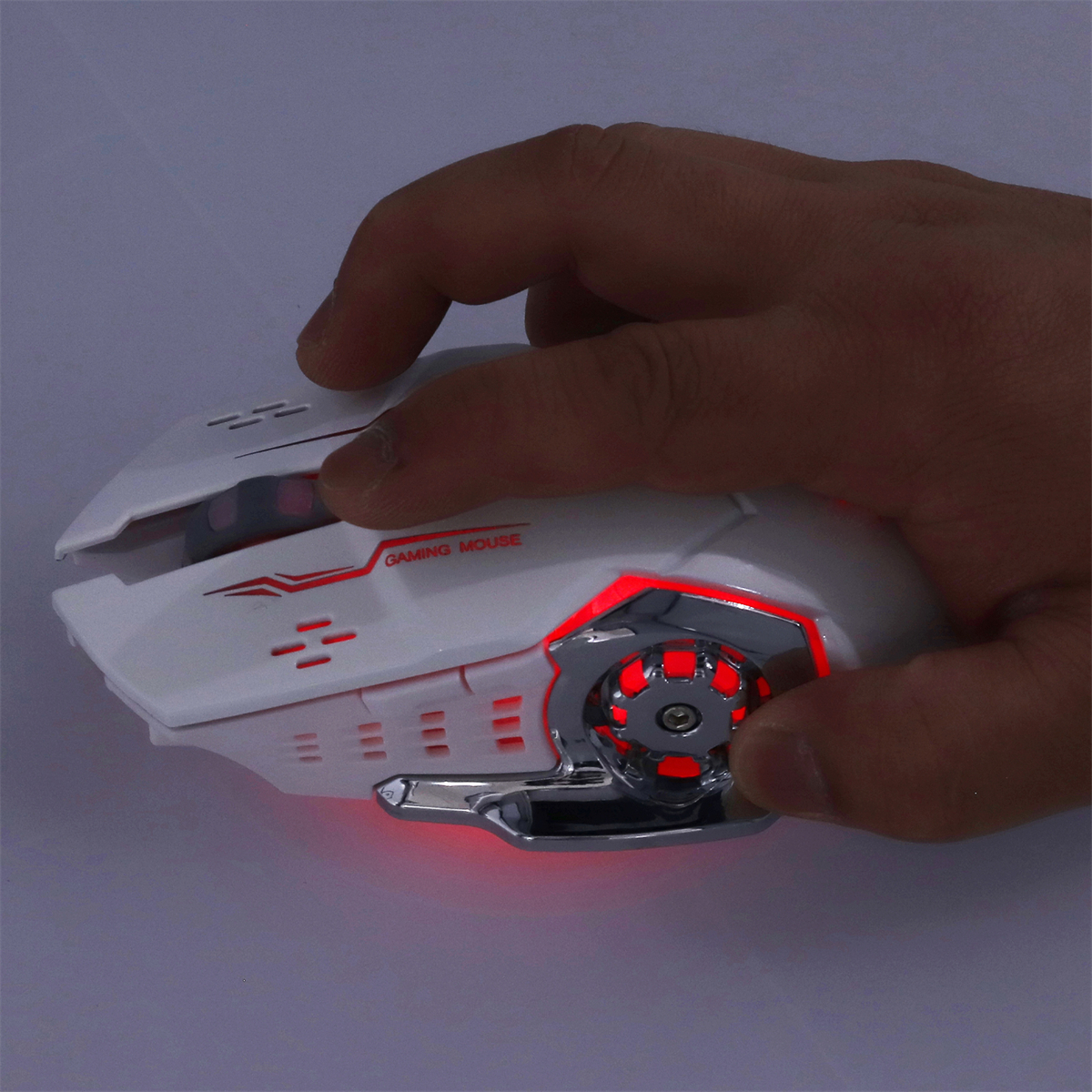 Weiße Gaming-Maus mit roter Beleuchtung. Eine Hand hält die Maus. Das Rad ist sichtbar.