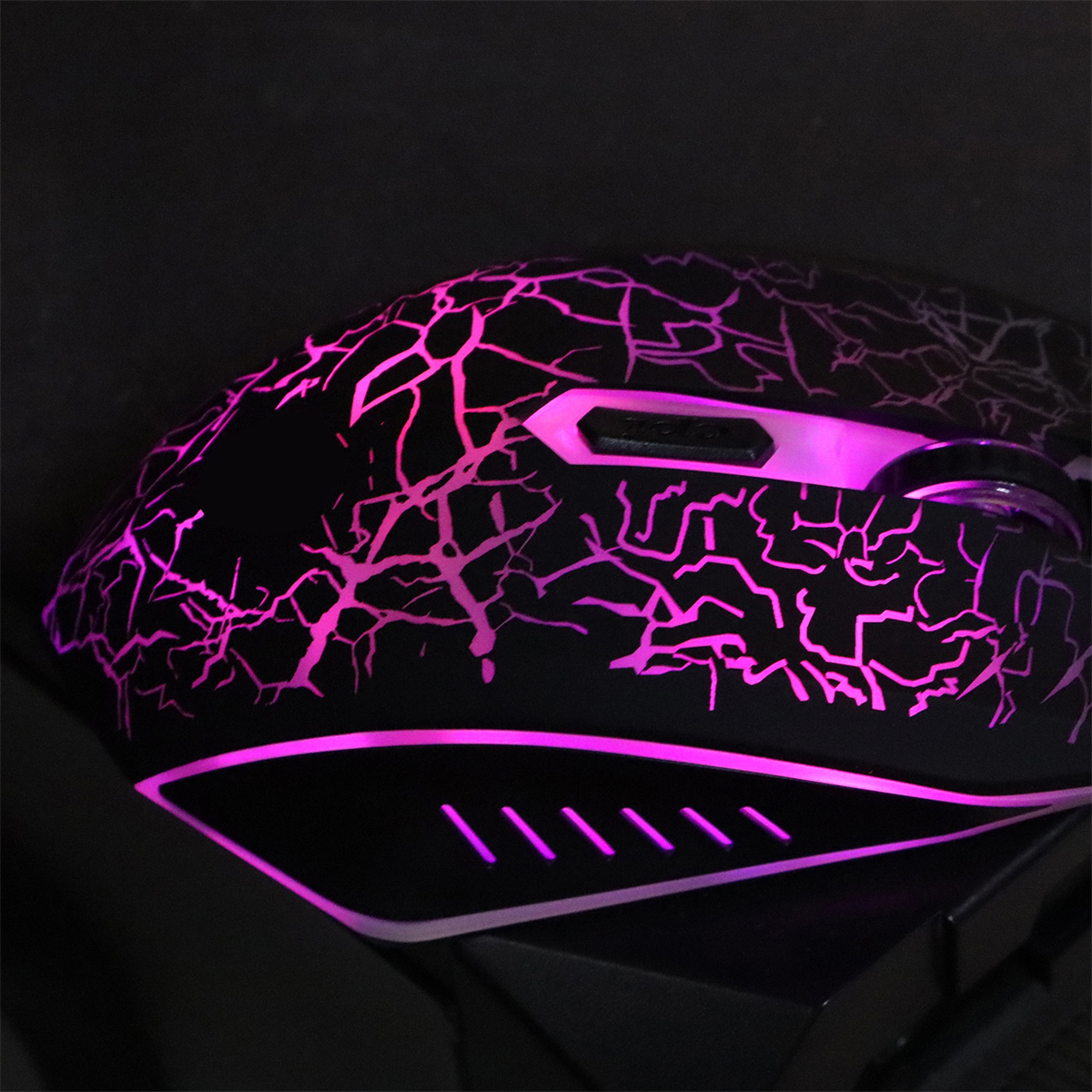 Eine Gaming-Maus mit schwarzem Gehäuse und pinkfarbenem Knister-Design, auf schwarzem Hintergrund.