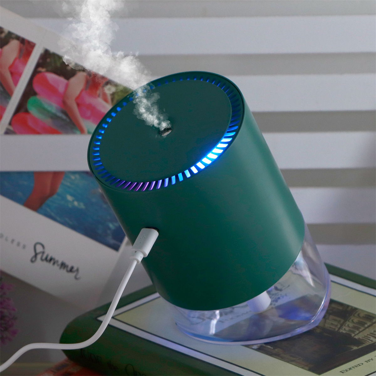 Ein grüner Luftbefeuchter mit blauen Lichtern und einem USB-Kabel, der Dampf abgibt.
