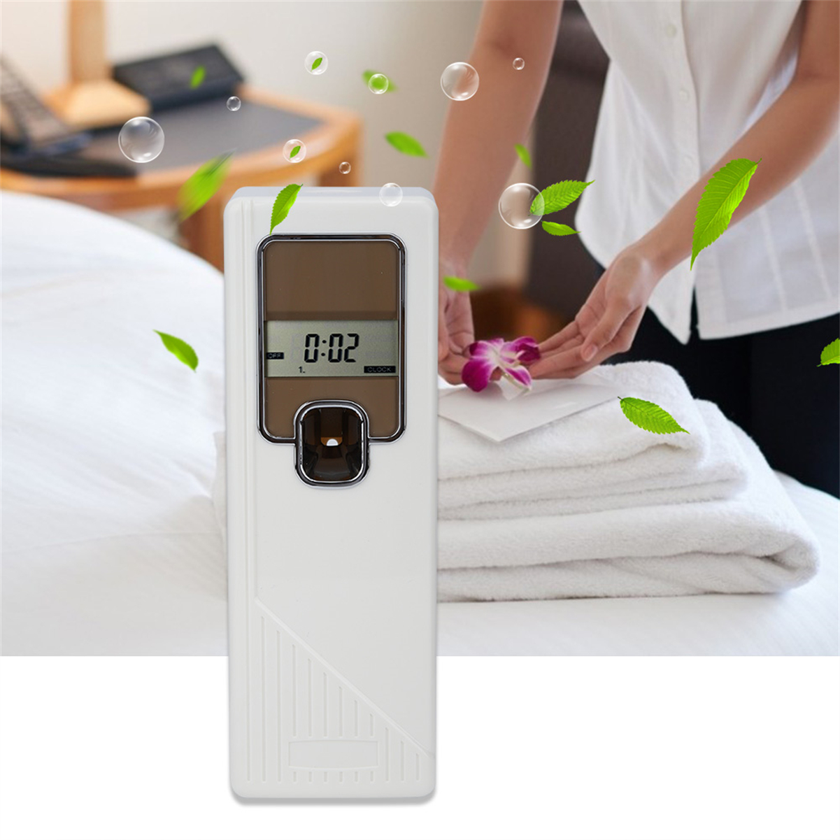 Ein Lufterfrischer mit Blumen und Blättern auf einem weißen Bett. Eine Person im Hintergrund.