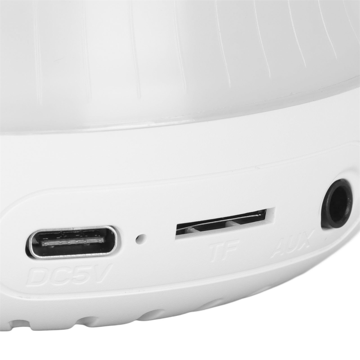 Nahaufnahme eines Sockels einer weißen LED-Lampe mit einem DC5V-Anschluss, TF- und AUX-Anschlüssen.