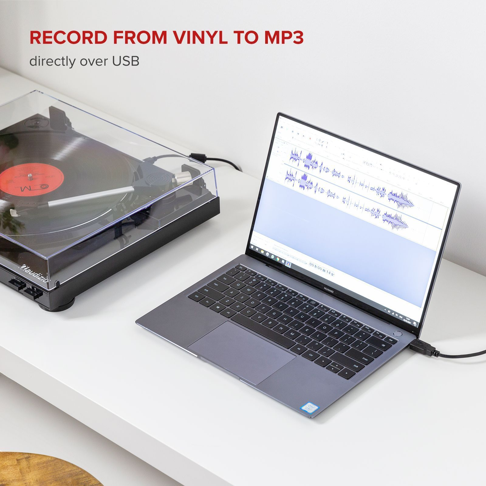Un tocadiscos graba en un portátil a través de USB. El portátil muestra la forma de onda de audio.