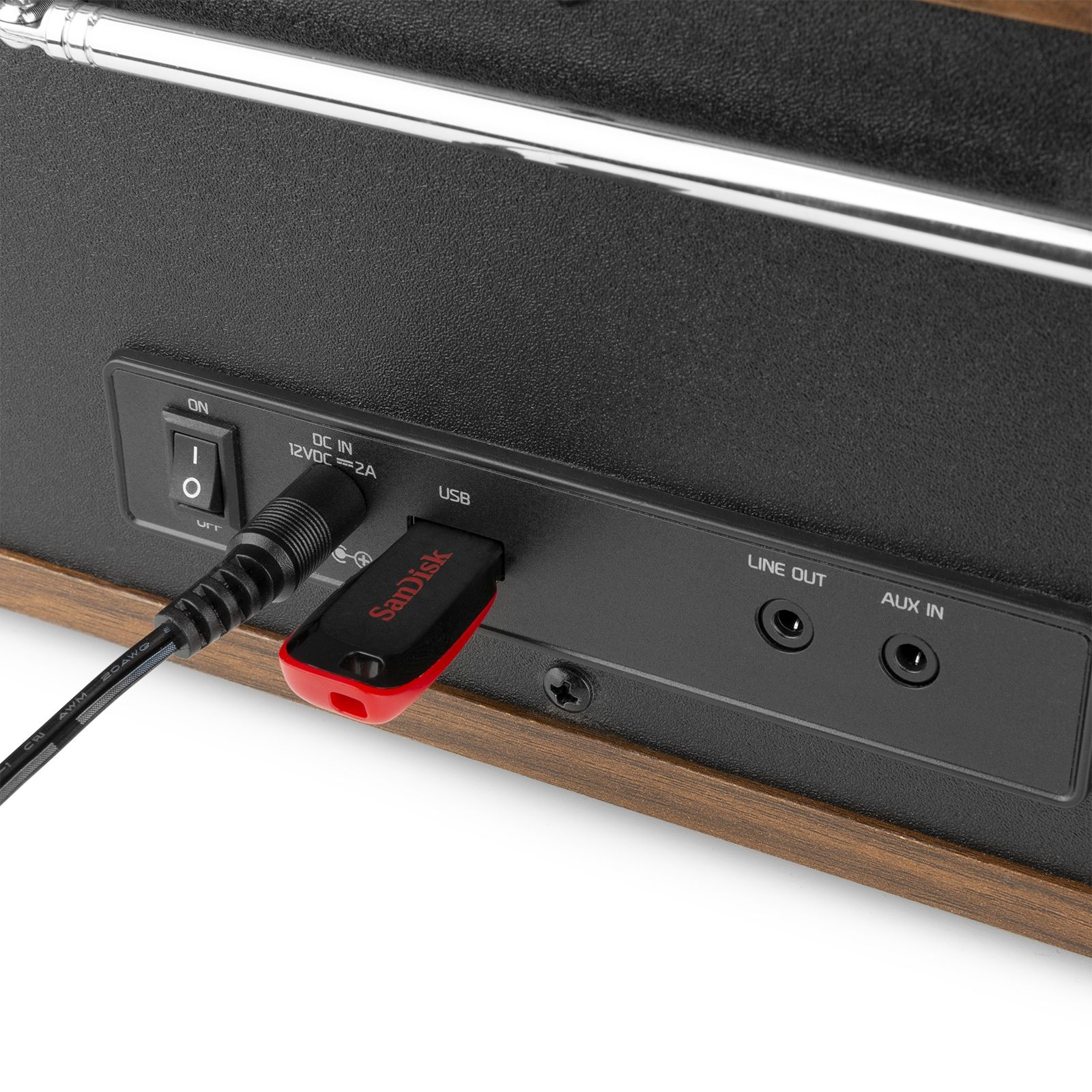 Gros plan du panneau arrière d'une radio. Clé USB insérée, avec ports d'alimentation et auxiliaire.