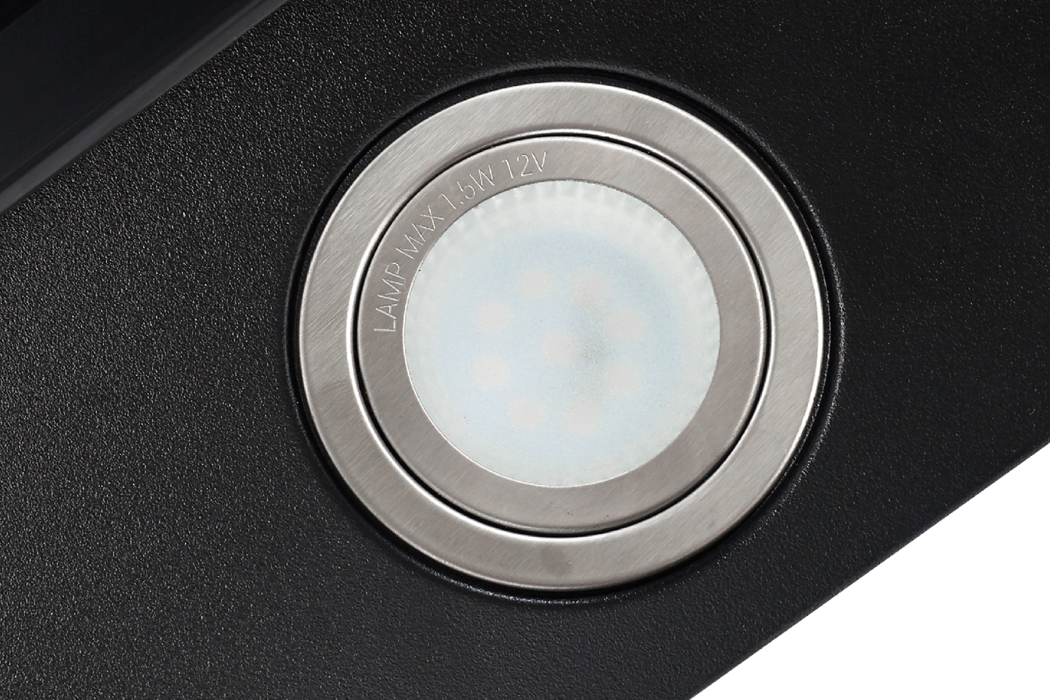 Close-up van een inbouwspot. Het licht wordt omgeven door een zilveren ring, binnen een zwart oppervlak.