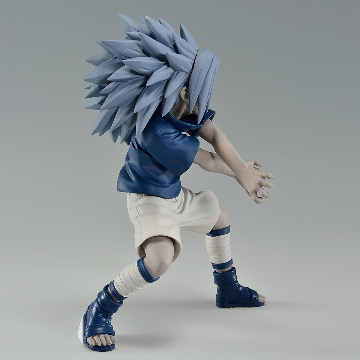 Una figura de un personaje de anime de pelo azul en una pose dinámica, vistiendo ropa azul y blanca.