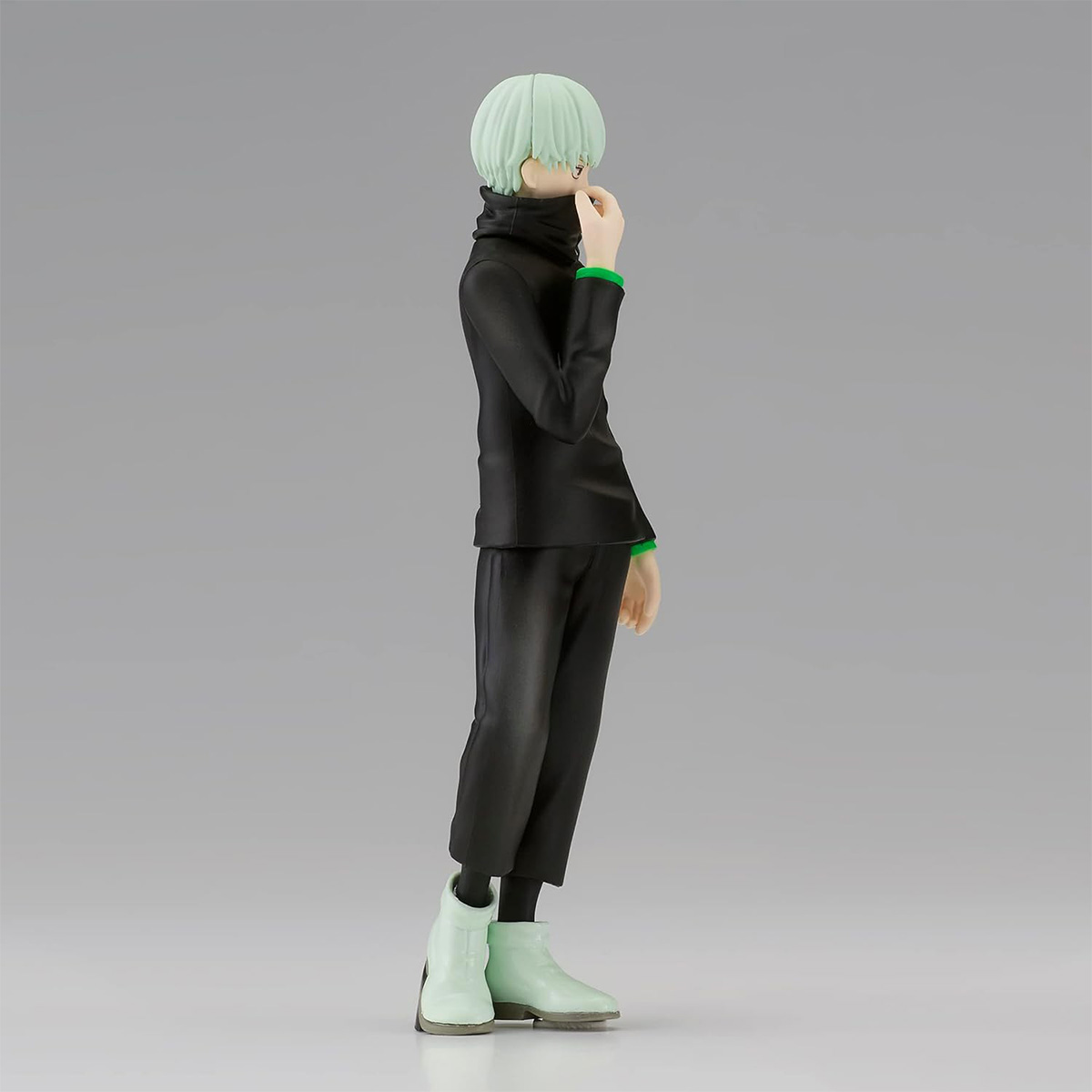 Eine Figur einer Person in einem schwarzen Outfit mit grünem Kragen und mintgrünen Stiefeln, die seitwärts steht.