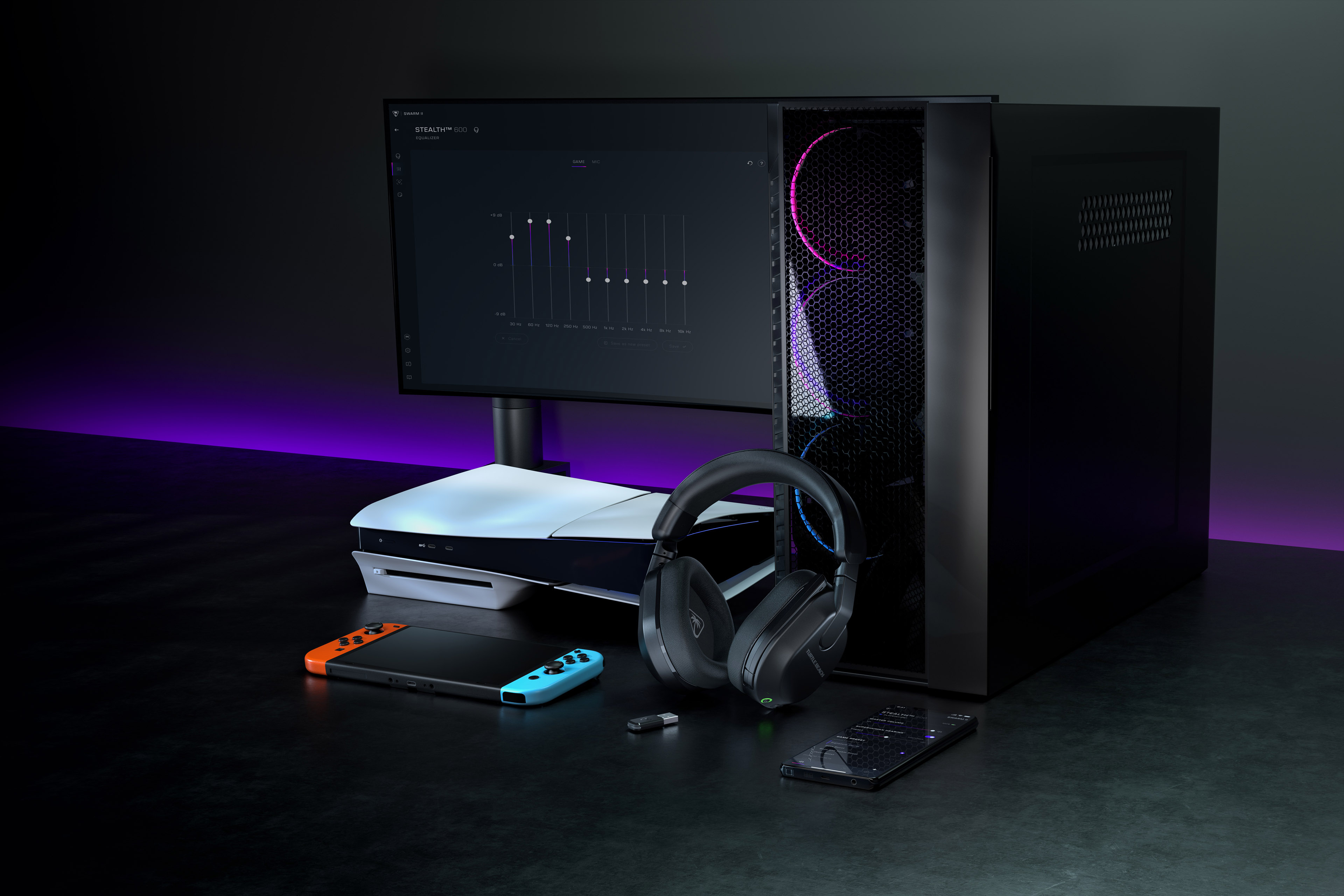 Konfiguracja gamingowa z komputerem, monitorem, zestawem słuchawkowym, konsolą, kontrolerem i telefonem na ciemnej powierzchni.