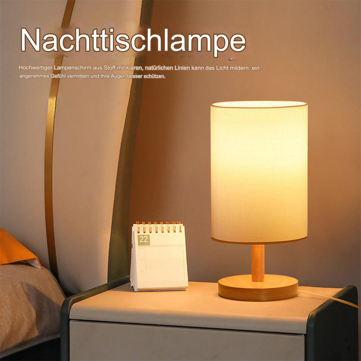 Ein Nachttisch mit einer beleuchteten Tischlampe und einem Kalender, die eine warme Atmosphäre schaffen.