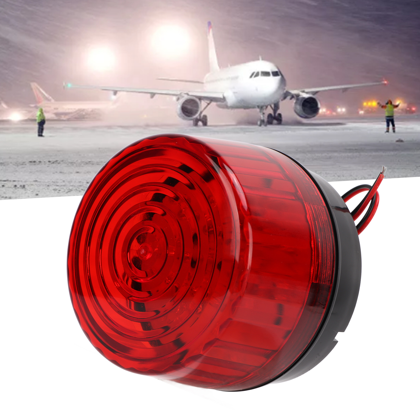 Ein rotes Licht für Flugzeuge und andere Fahrzeuge. Im Hintergrund ist nachts ein Flugzeug zu sehen.