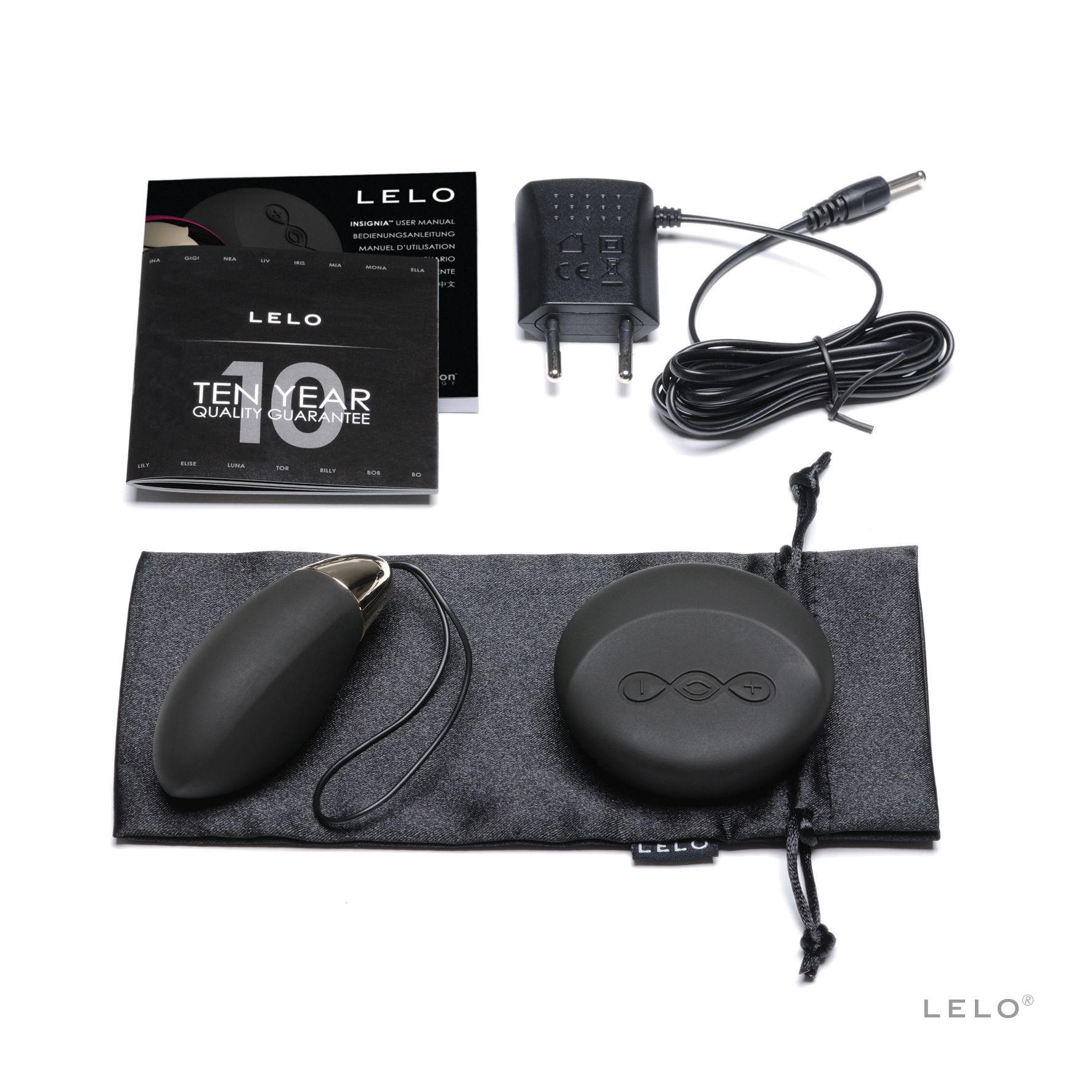 Vibrador Lelo negro con accesorios y embalaje sobre una superficie blanca.