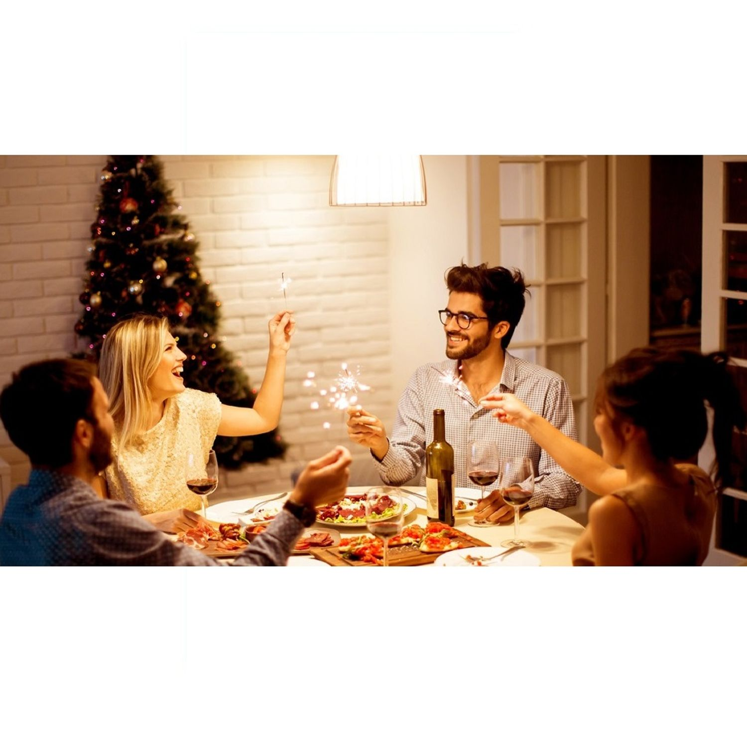 Grupa osób przy stole z racami i winem.