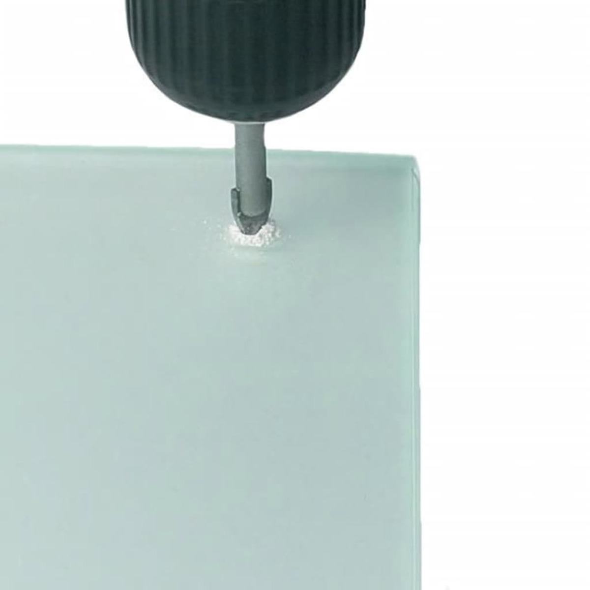 Ein Bohrer bohrt ein Loch in ein Glas. Der Bohrer ist schwarz und das Glas ist weiß.