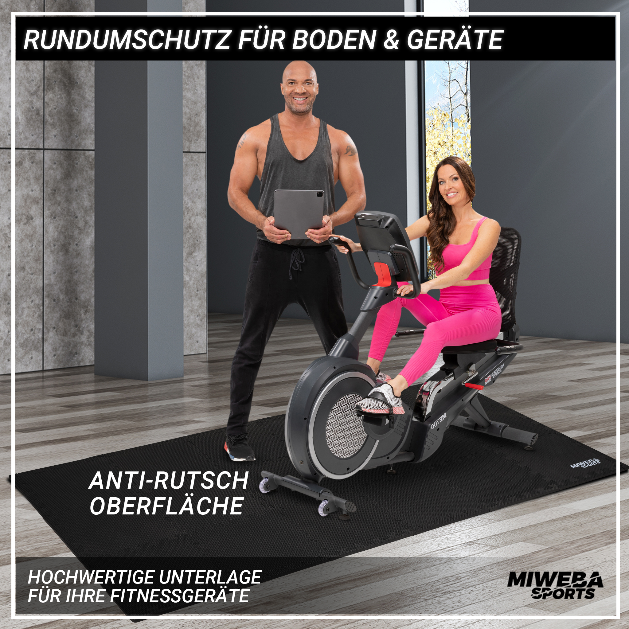 Ein Mann und eine Frau in der Nähe eines Liegefahrrads auf einer schwarzen Matte.