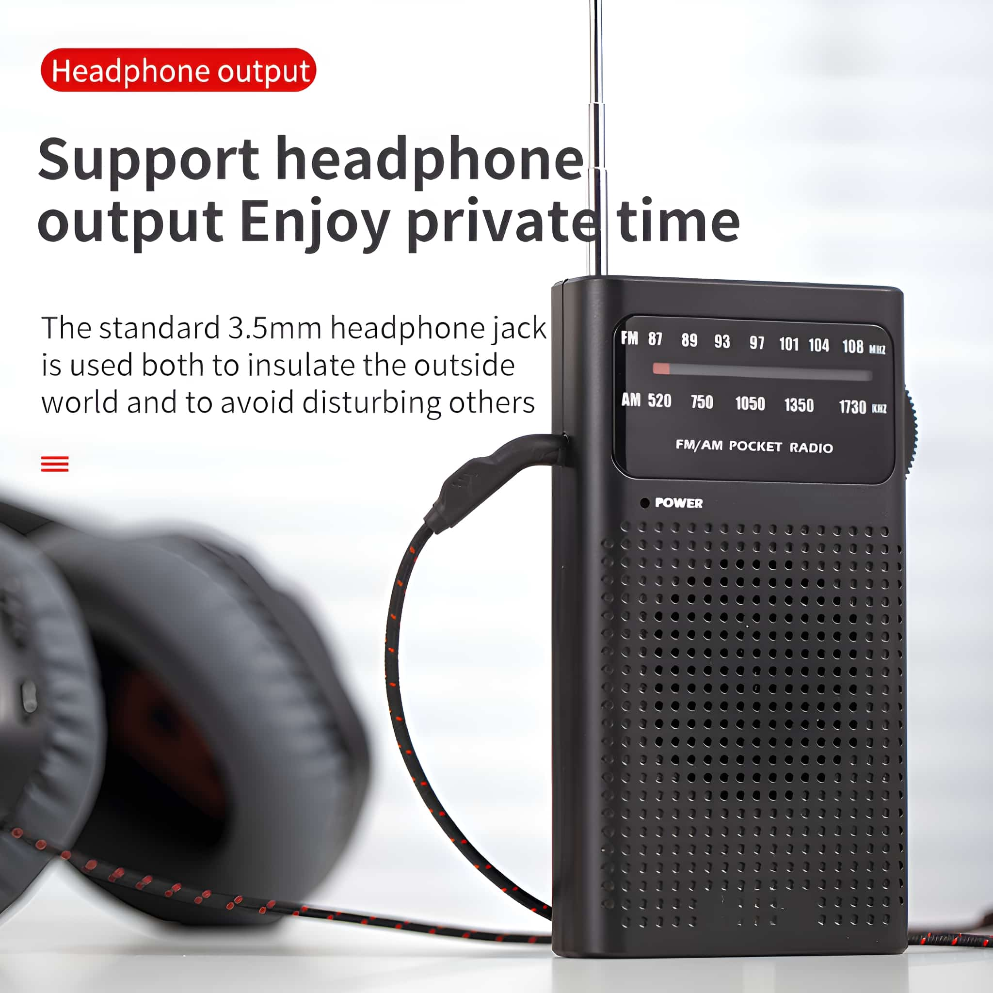 Ein schwarzes FM/AM-Taschenradio mit angeschlossenen Kopfhörern auf hellem Hintergrund.