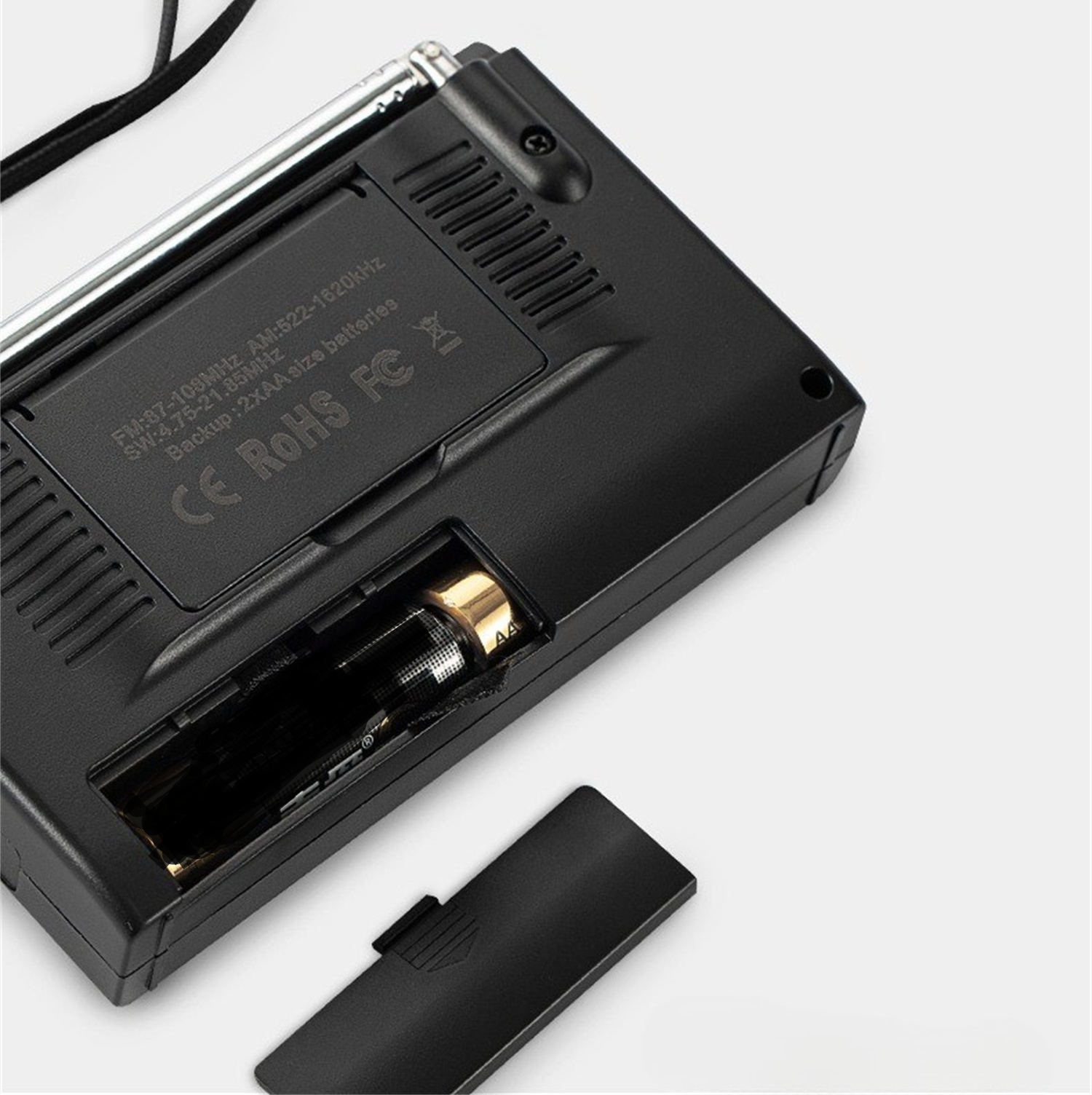 Schwarzes Radio mit geöffnetem Batteriefach, das Batterien und eine schwarze Abdeckung zeigt.