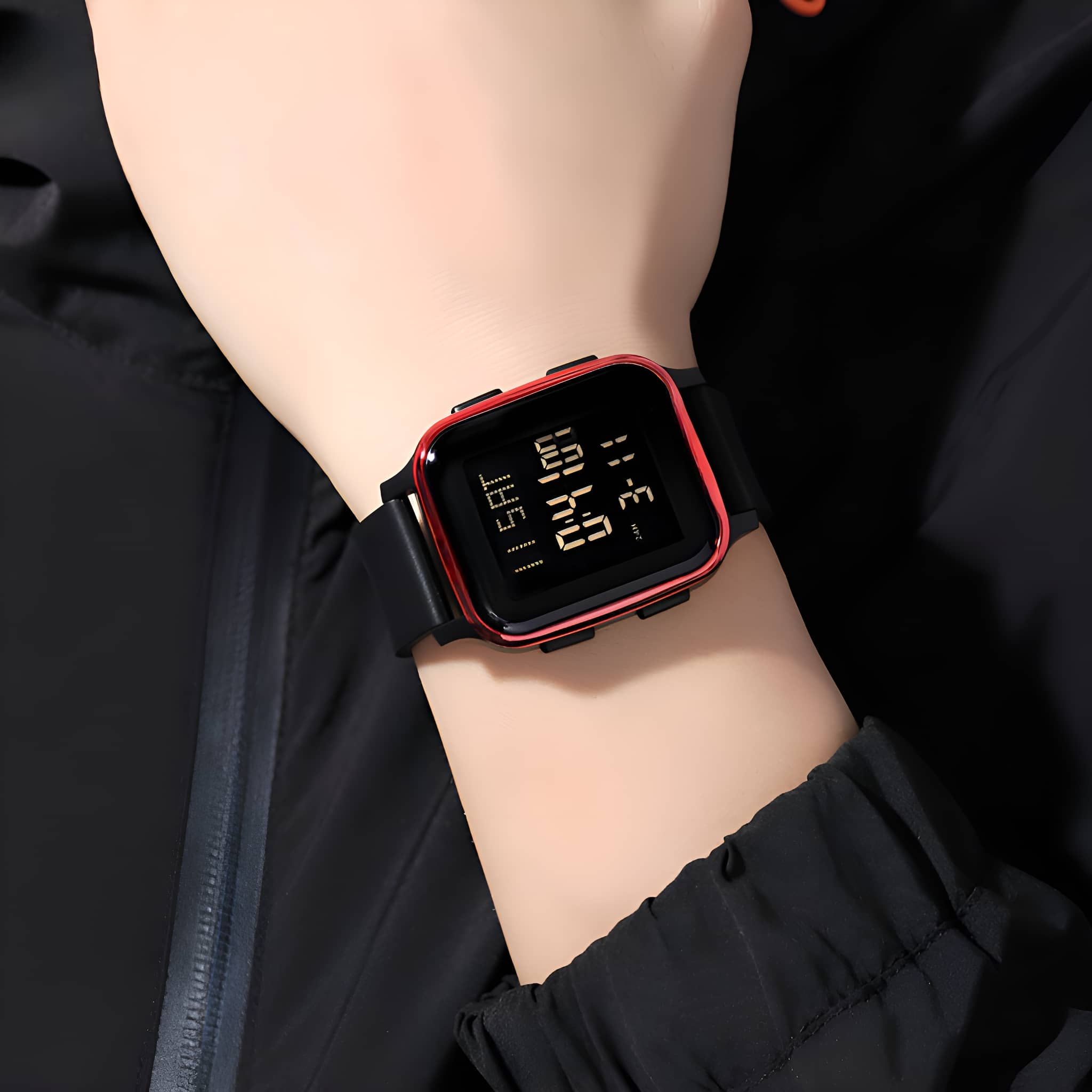 Handgelenk mit Digitaluhr. Die Uhr hat ein schwarzes Armband und einen rot umrandeten Bildschirm.
