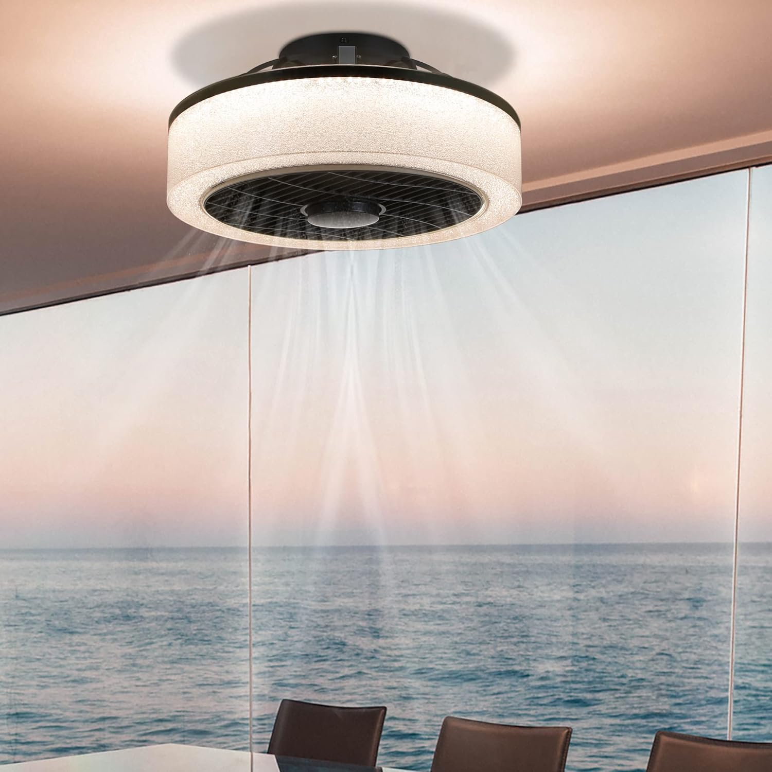 Un ventilatore a soffitto con una luce, su una vista mare attraverso una finestra.