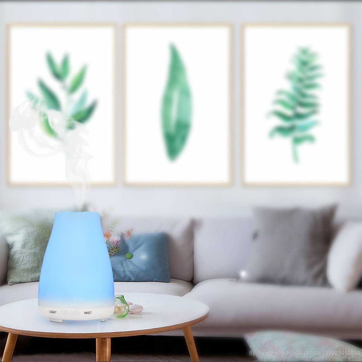 Blau-weißer Diffusor für ätherische Öle mit Kunst im Hintergrund. Ein Licht scheint.