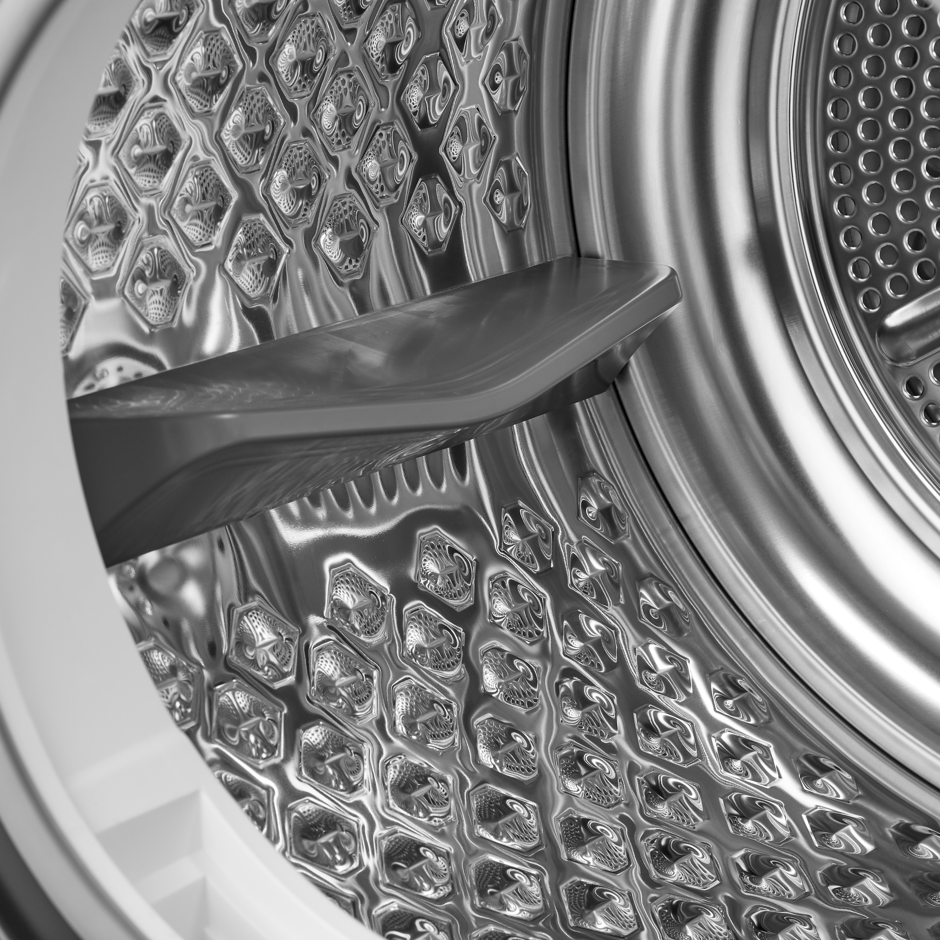 Close-up of the inside of a dryer drum. The interior is metallic, with a rotating element.