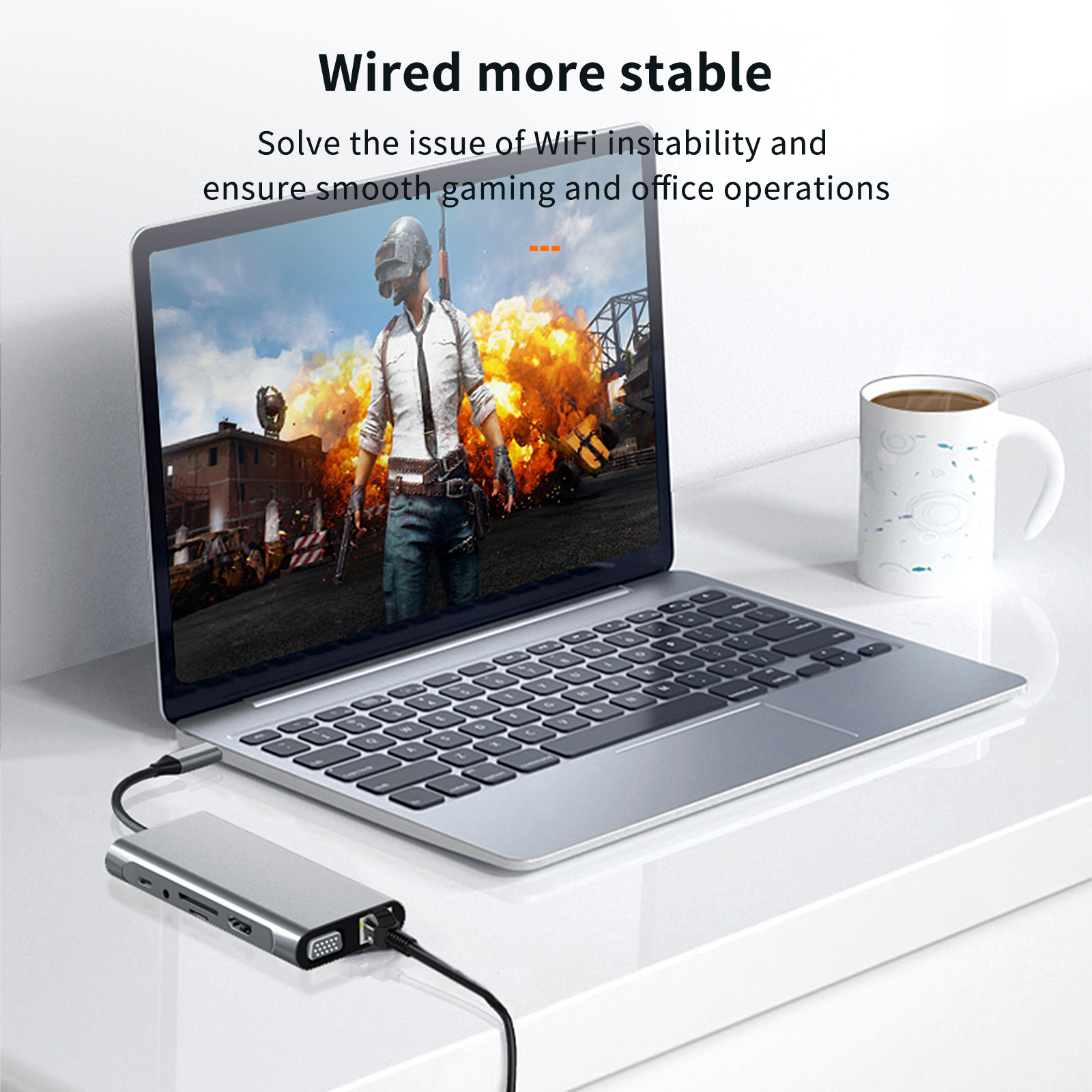 Ein Laptop und ein Gerät stehen auf einem weißen Tisch. Der Bildschirm zeigt ein Spiel mit einer großen Explosion.