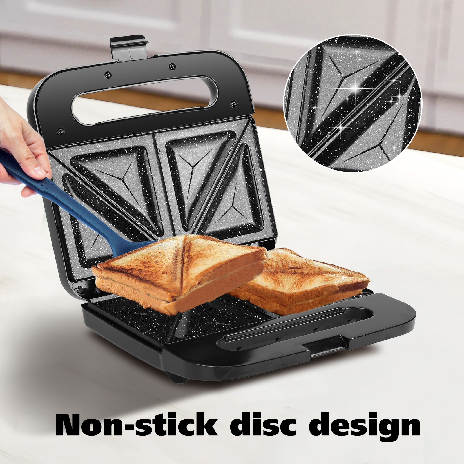 Una sandwichera negra con dos sándwiches tostados dentro. Una espátula azul se inserta en la máquina.