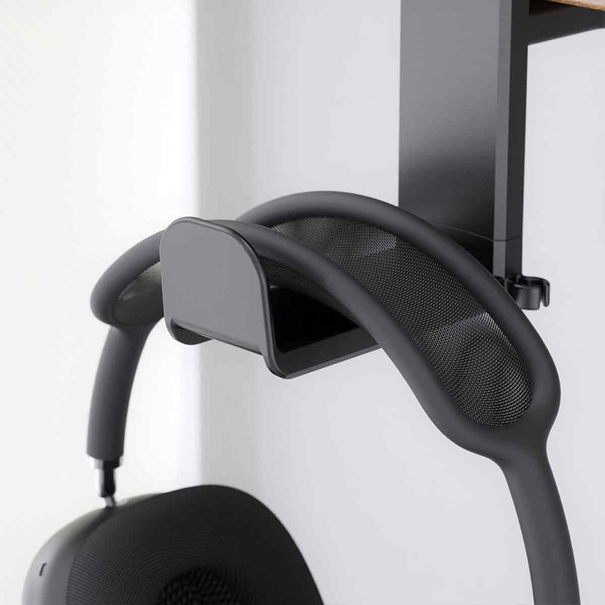 Kopfhörer hängen an einem schwarzen Halter an einer weißen Wand. Der Halter hat ein Mesh-Design.