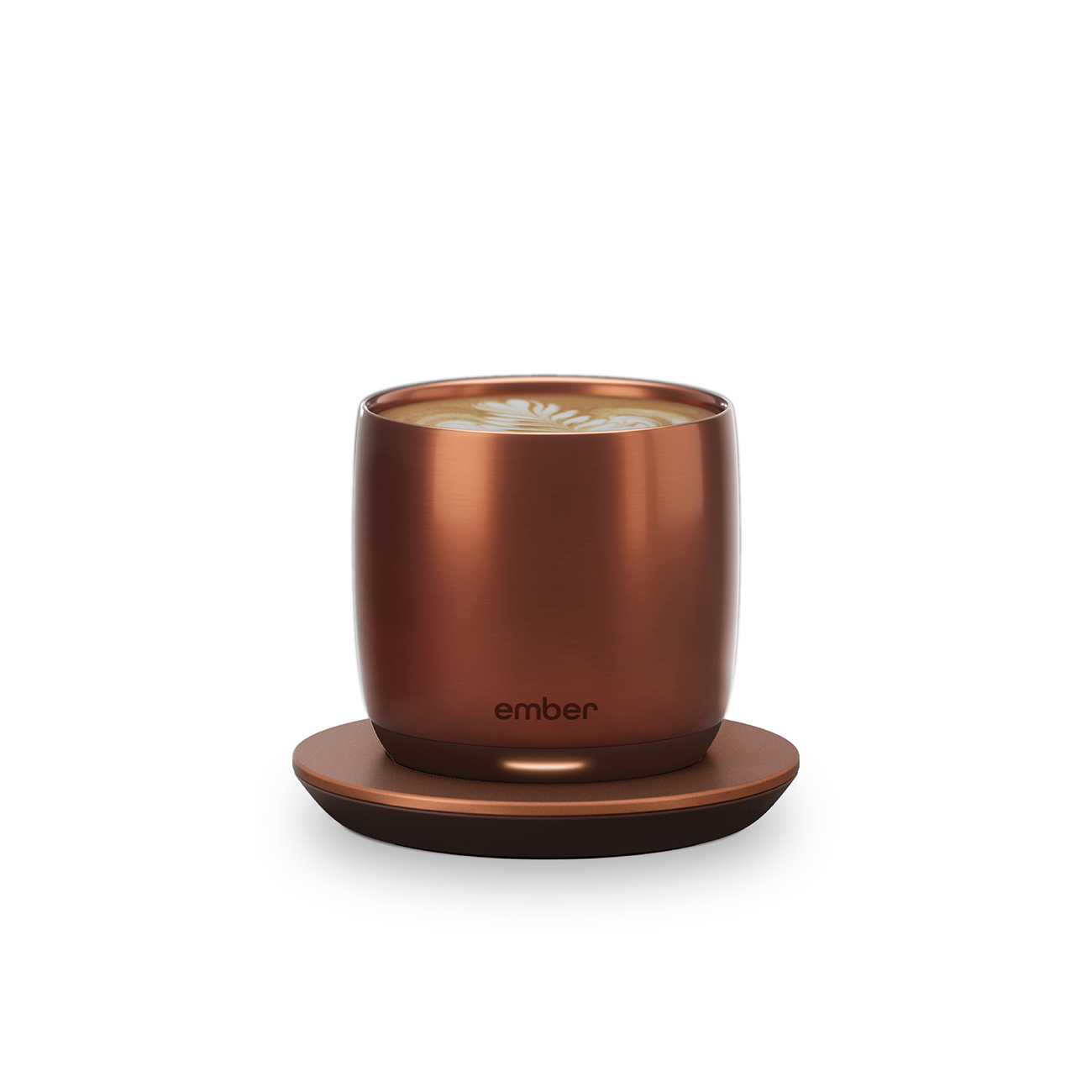 Una tazza color rame con un latte, appoggiata su un sottobicchiere color rame.