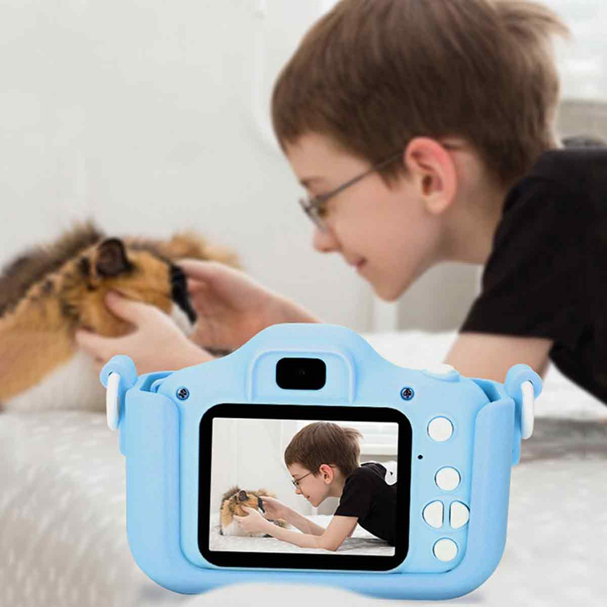 Ein Kind blickt durch eine blaue Kamera auf eine Katze im Zimmer. Der Bildschirm zeigt die Szene.